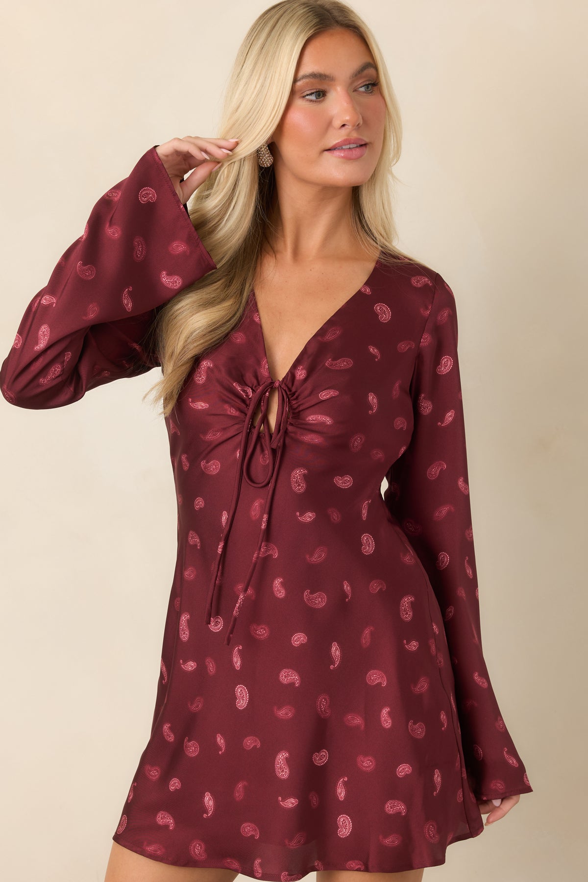 Satin mini dress showcasing the V-neckline and center-front knot detail.