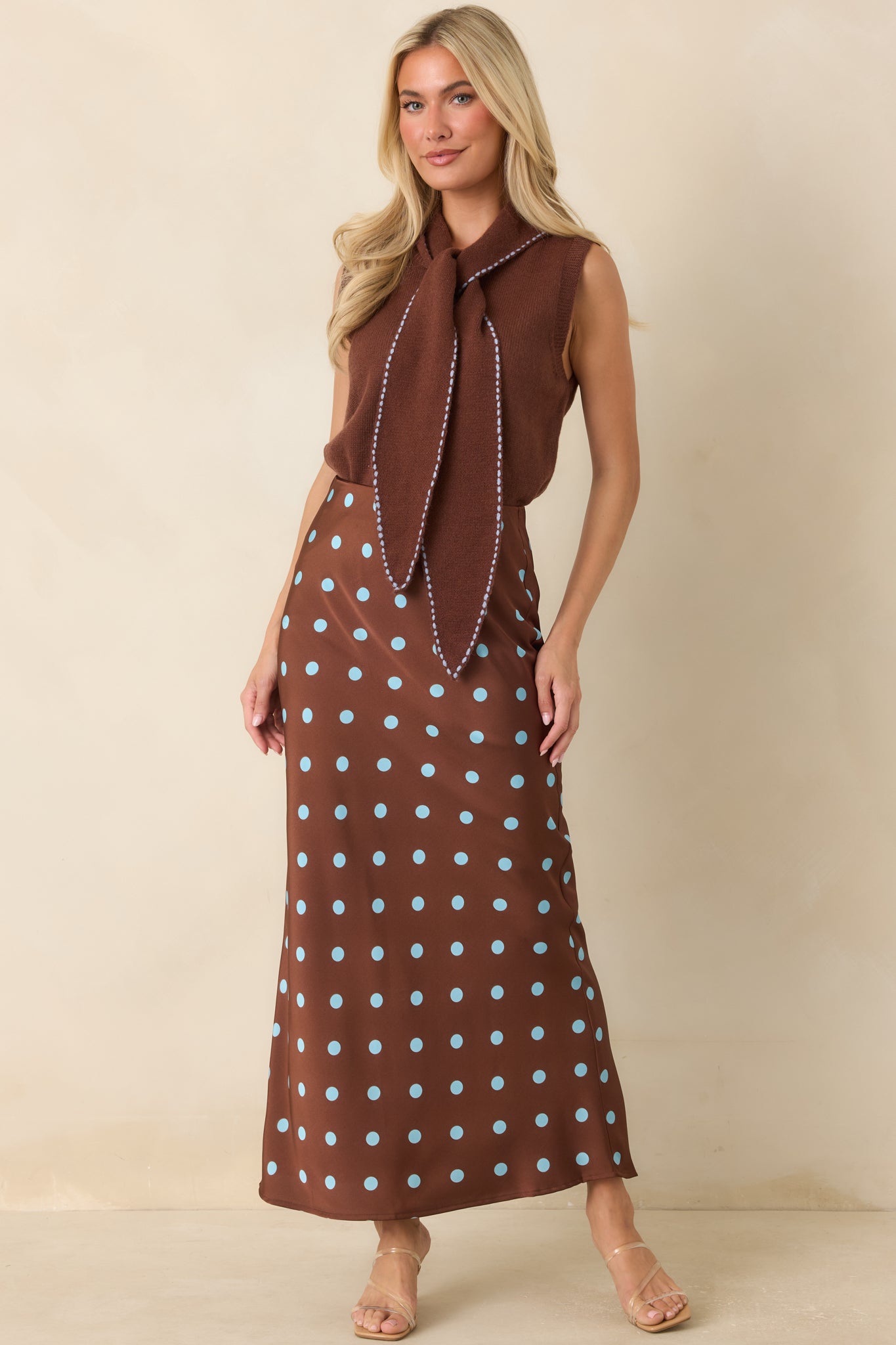 Satin midi skirt showcasing a rich chocolate brown backdrop, scattered light blue polka dots, and an easy elastic waistband.