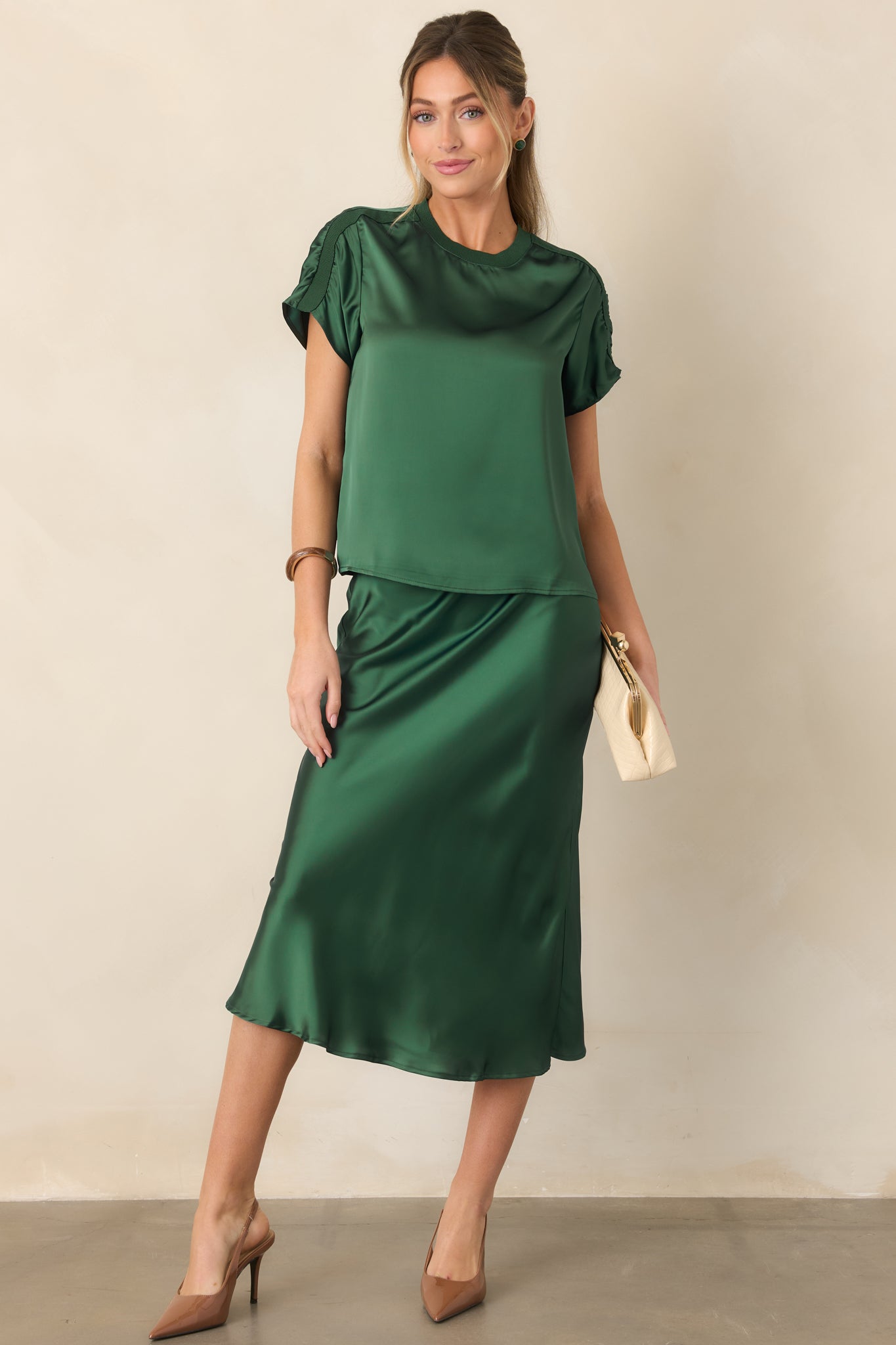 Sleek satin midi skirt featuring an easy pull-on design, elastic waistband, fluid silhouette, and softly flared hem.