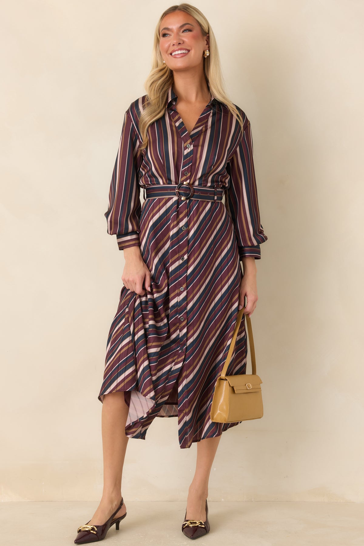 Satin shirt dress combining vertical bodice stripes with diagonally arranged stripes through the skirt.