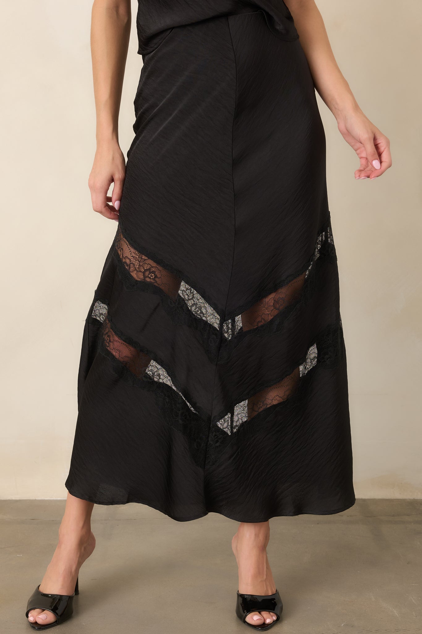 Satin skirt featuring a fluid drape, body-skimming fit, and feminine lace contrast along the lower portion.