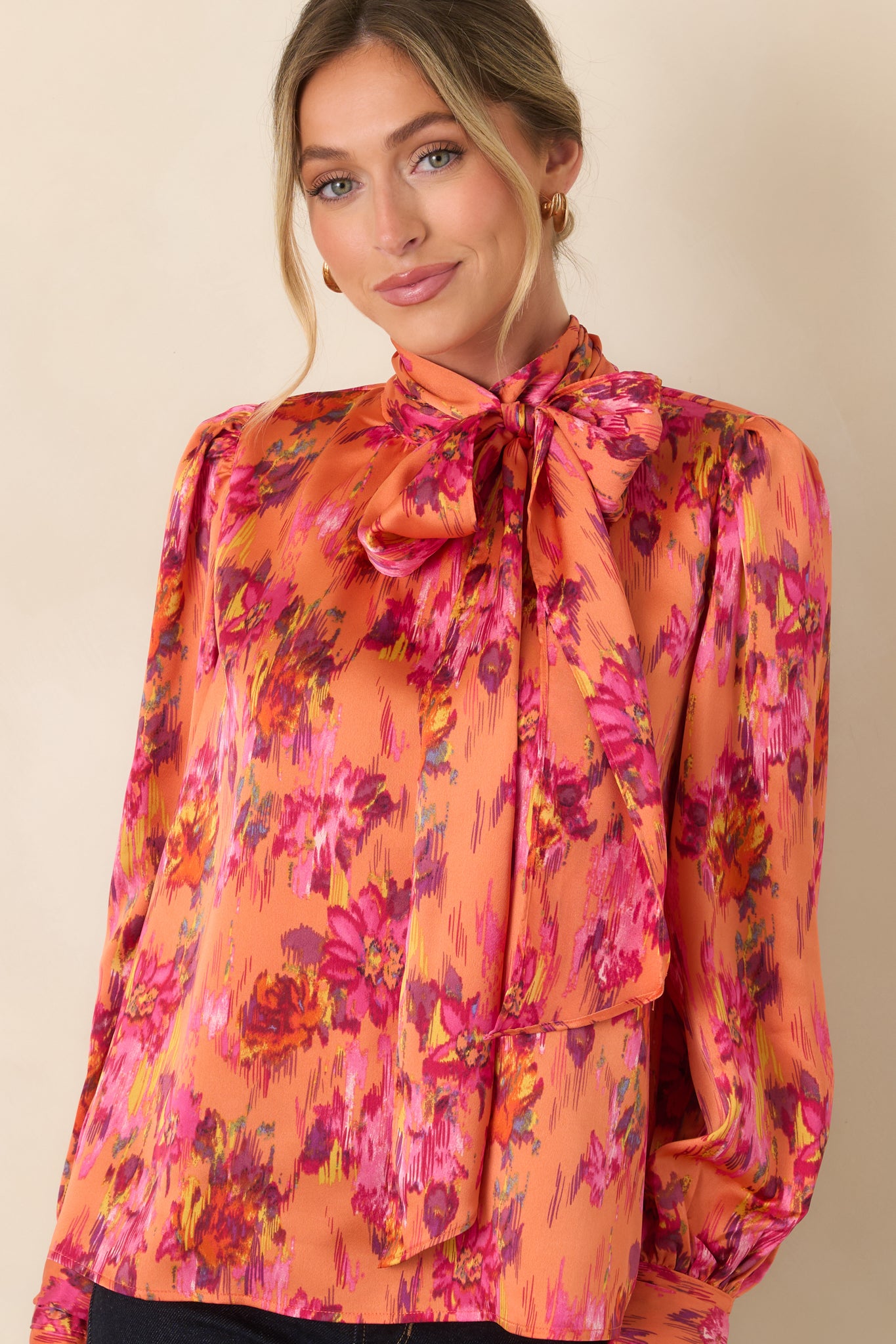 Front detail of the satin top highlighting the dramatic tie neckline and softly gathered shoulder construction.