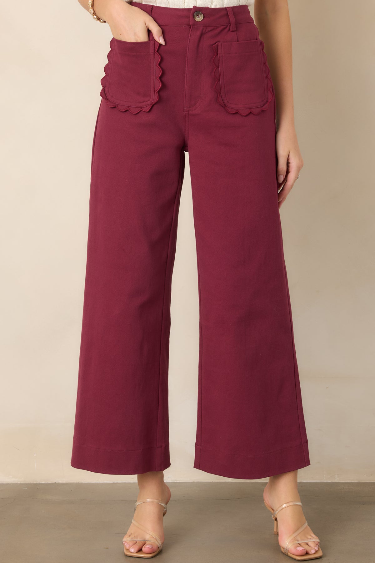 Detailed view of the feminine scalloped front patch pockets and structured woven cotton texture.