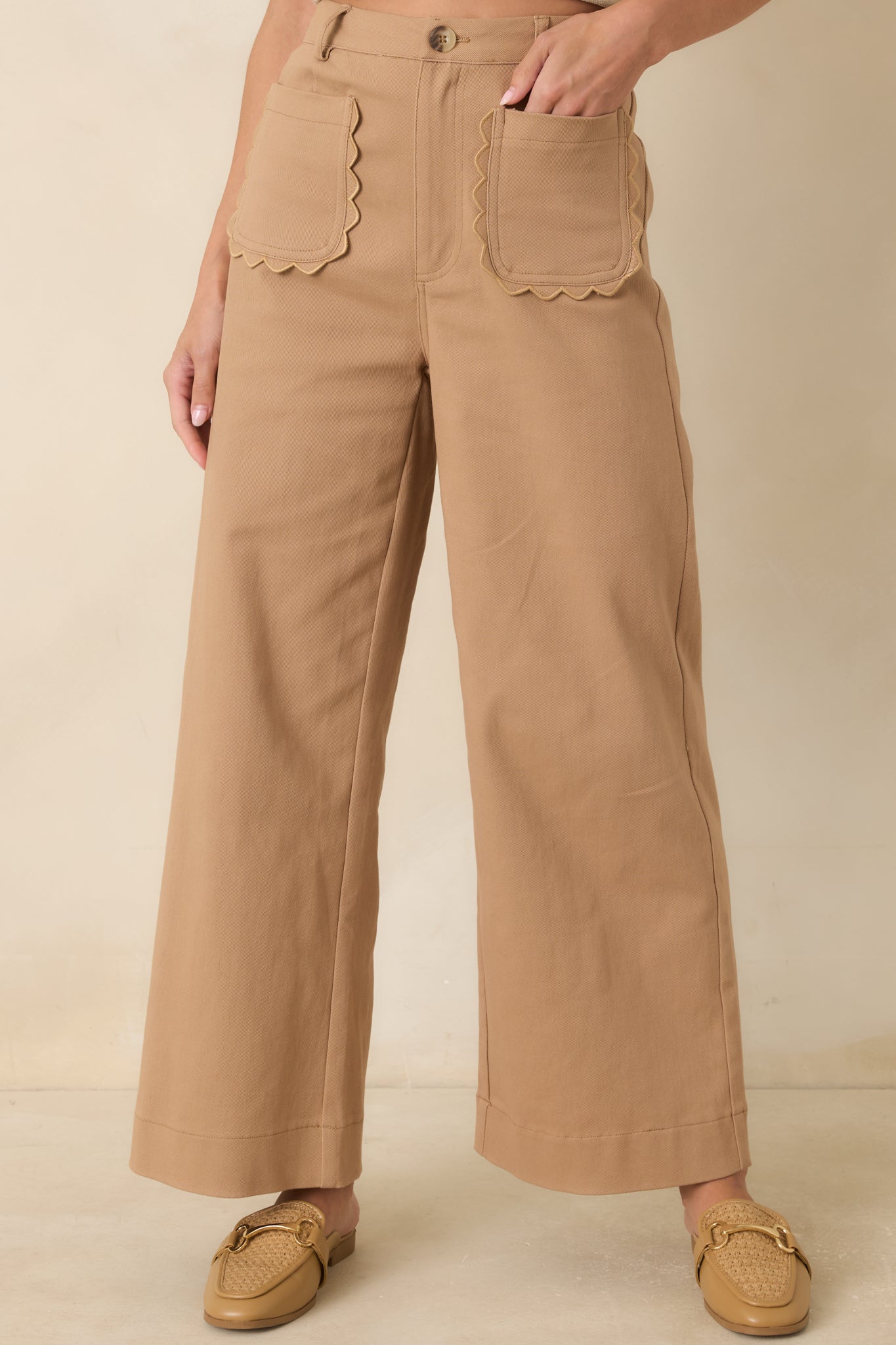 Detailed view of the scalloped front patch pockets highlighting the feminine design and warm camel fabric.