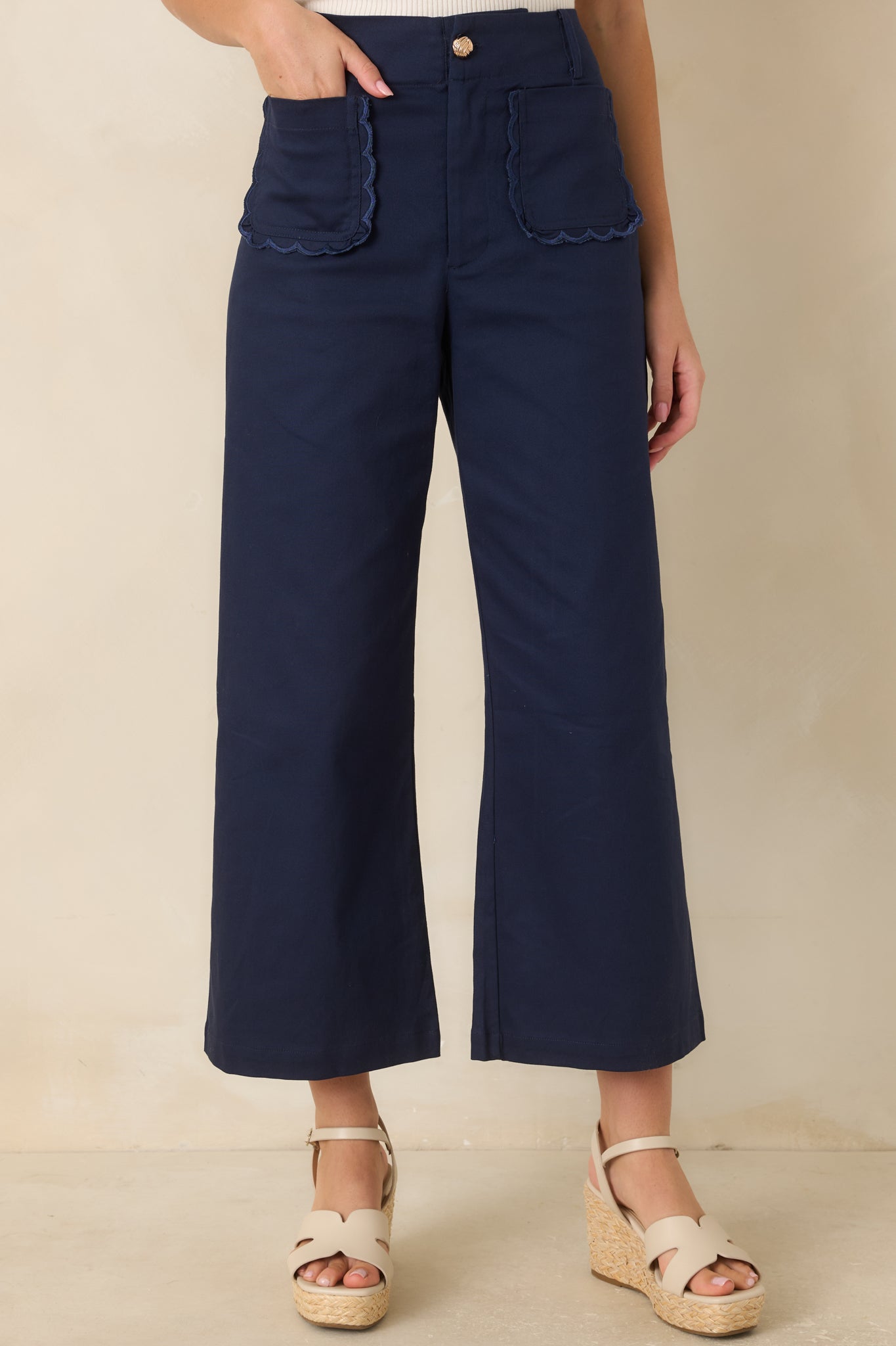 Close view of the scalloped trim along the front patch pockets and polished gold-tone button closure.