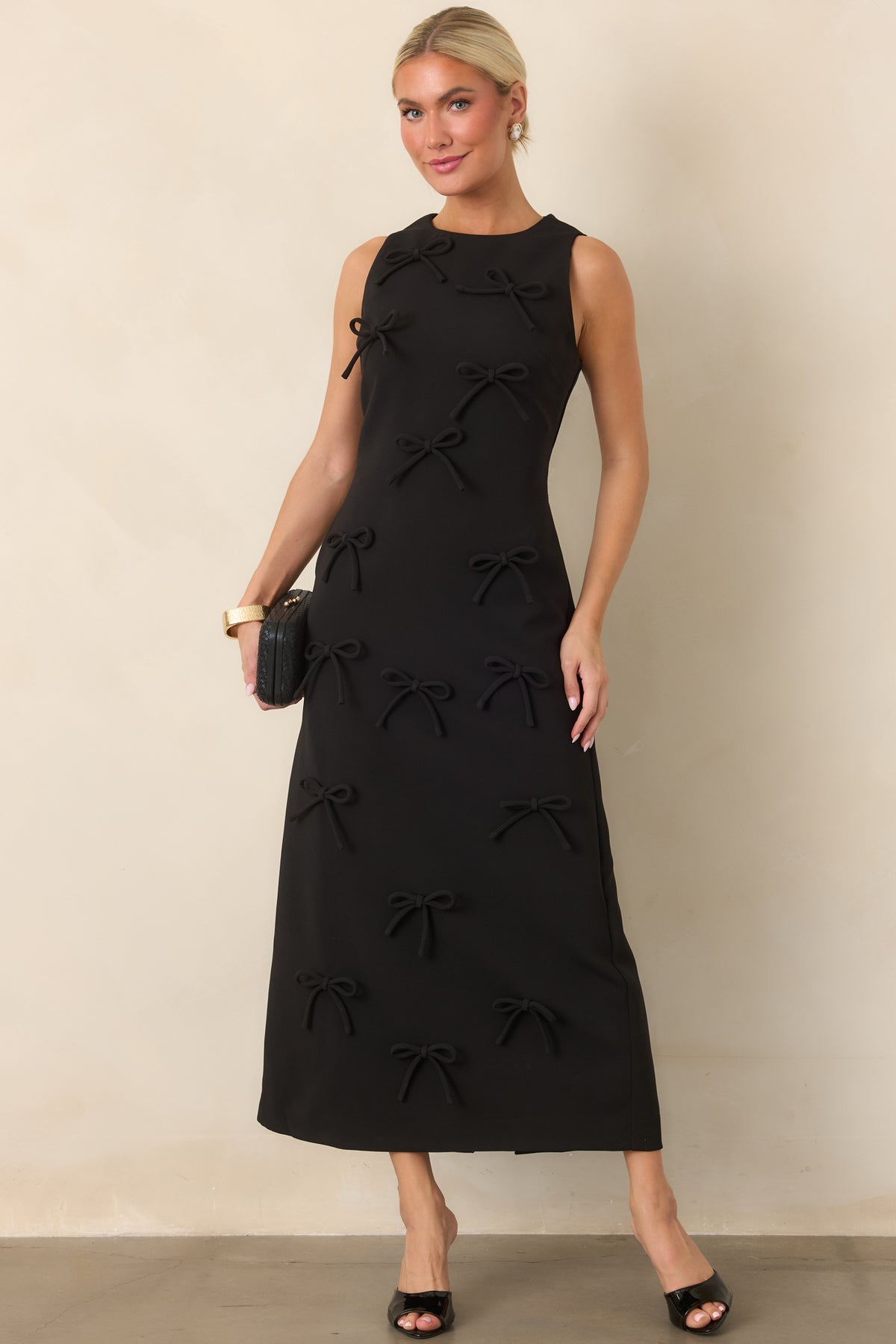 Streamlined maxi dress with a sculpted bodice, strategic seaming, and dimensional bows creating a playful textured finish.
