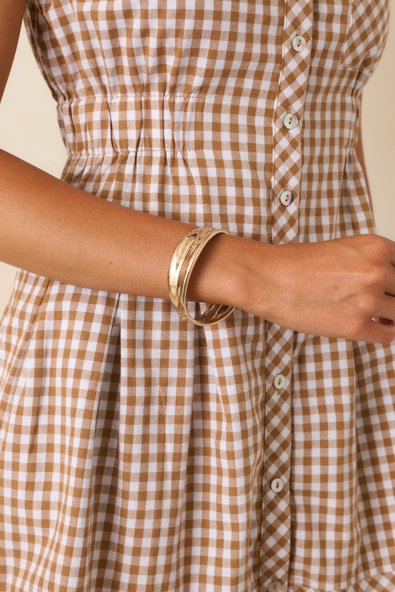 Sculptural bangle bracelet featuring a concave silhouette, alternating wide and narrow sections, and an organic polished shape.