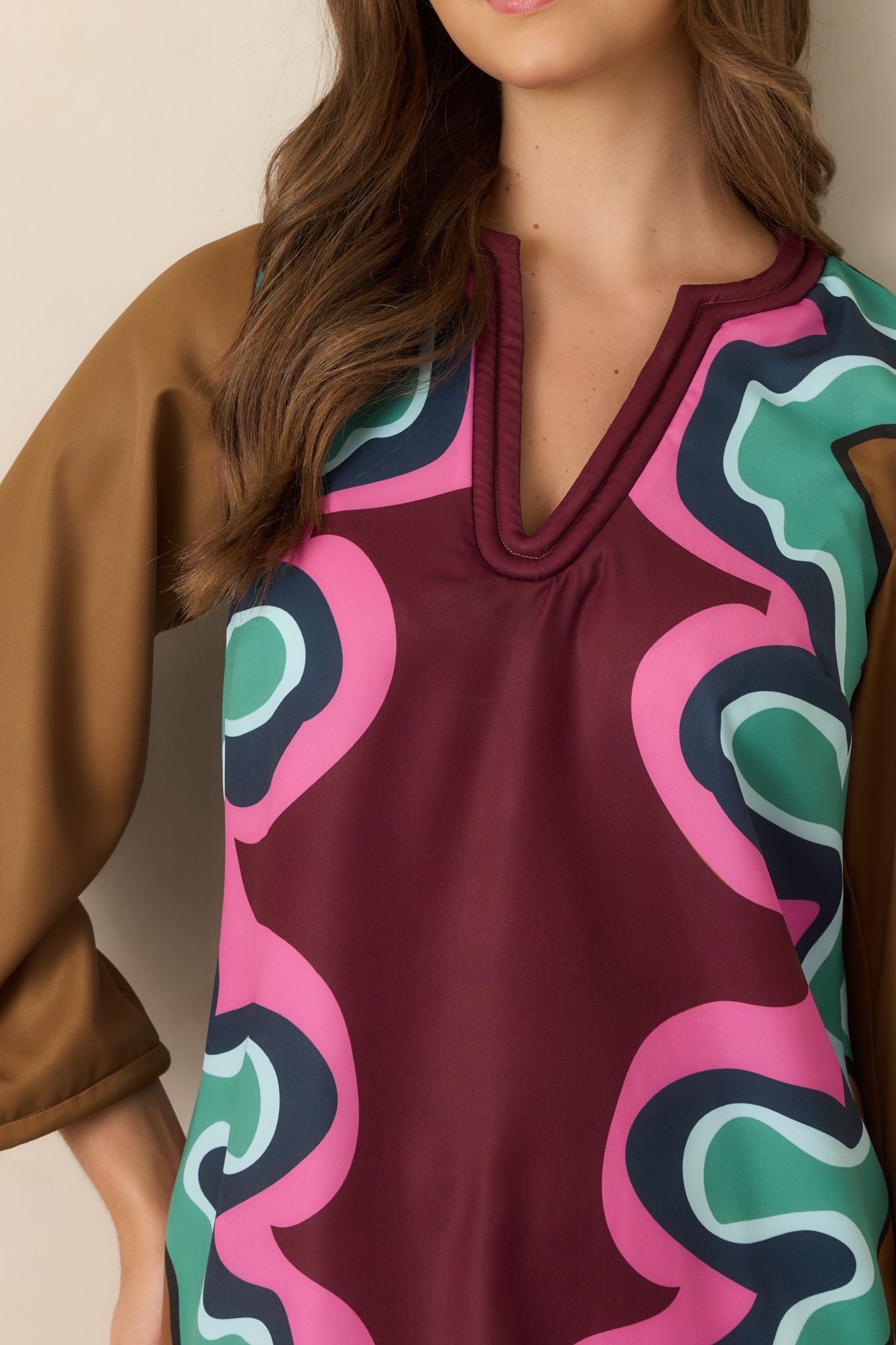 Close-up of the dress showcasing the soft corded V-neckline, coordinating trim, and intricate multicolored Serpentine pattern.