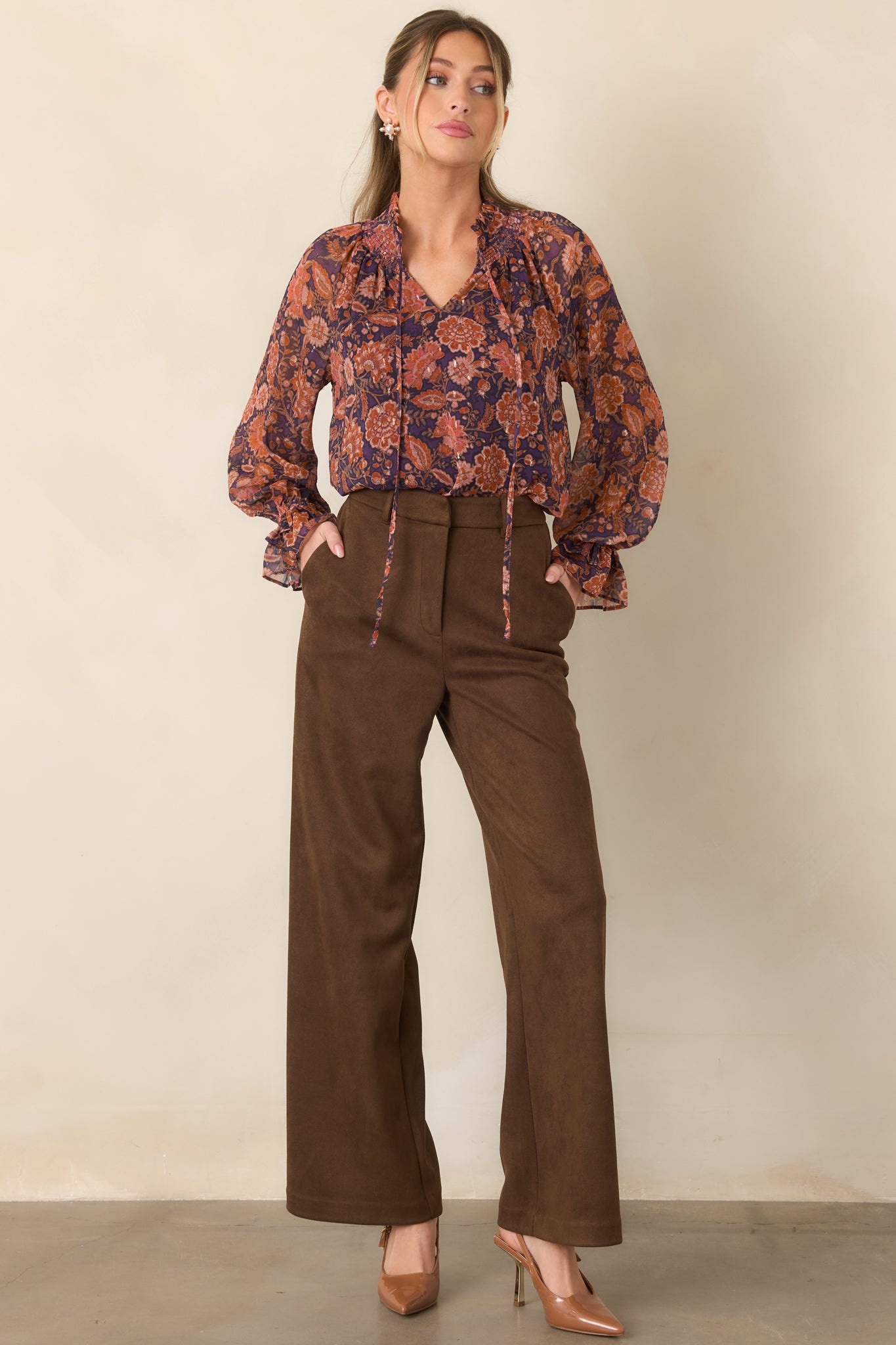 Floral blouse featuring a colorful sheer overlay, split neckline with ties, and softly draped long sleeves.