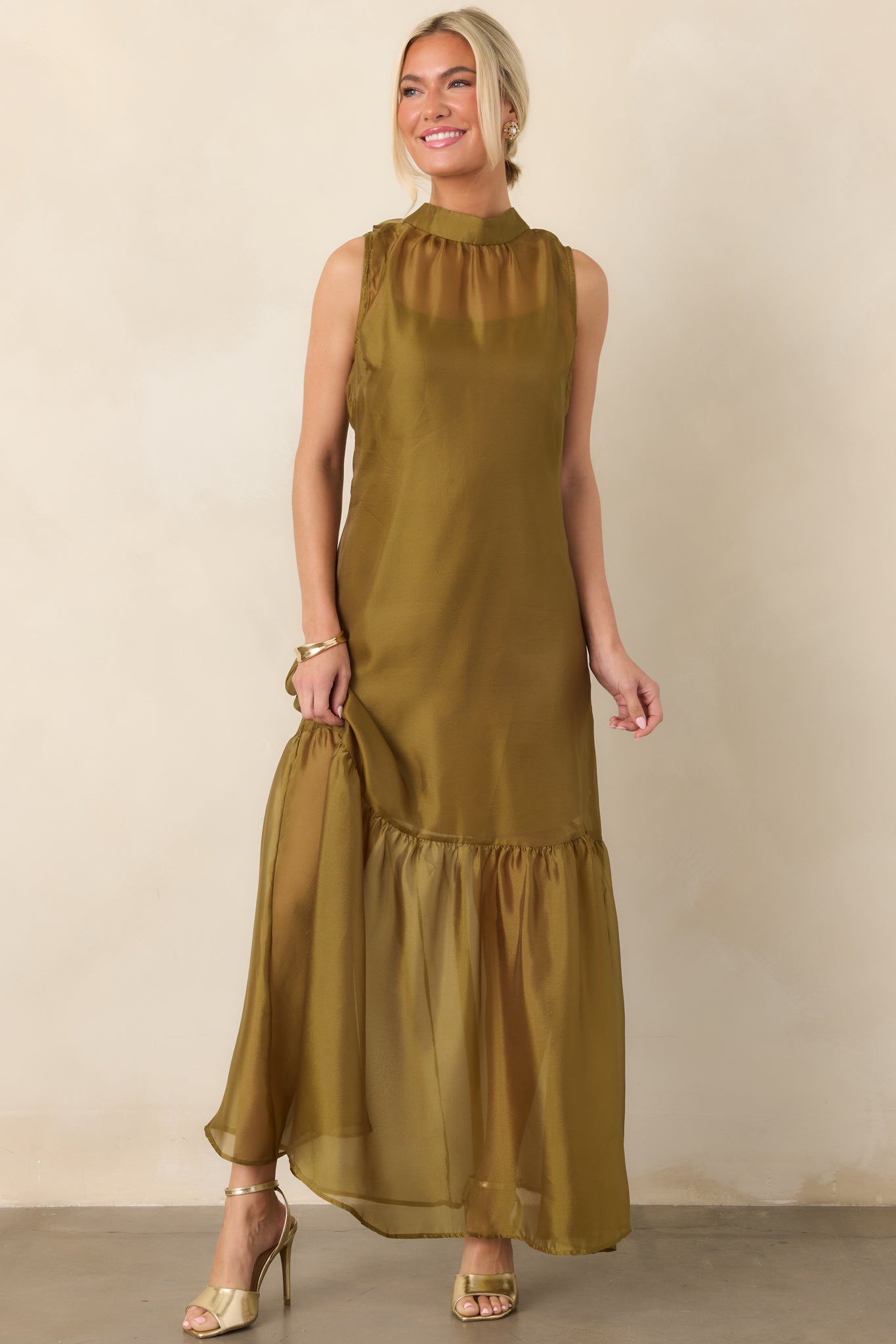 Sheer organza maxi dress with a graceful high neckline, flowing skirt, softly gathered hem, and layered mini-length slip lining for coverage.