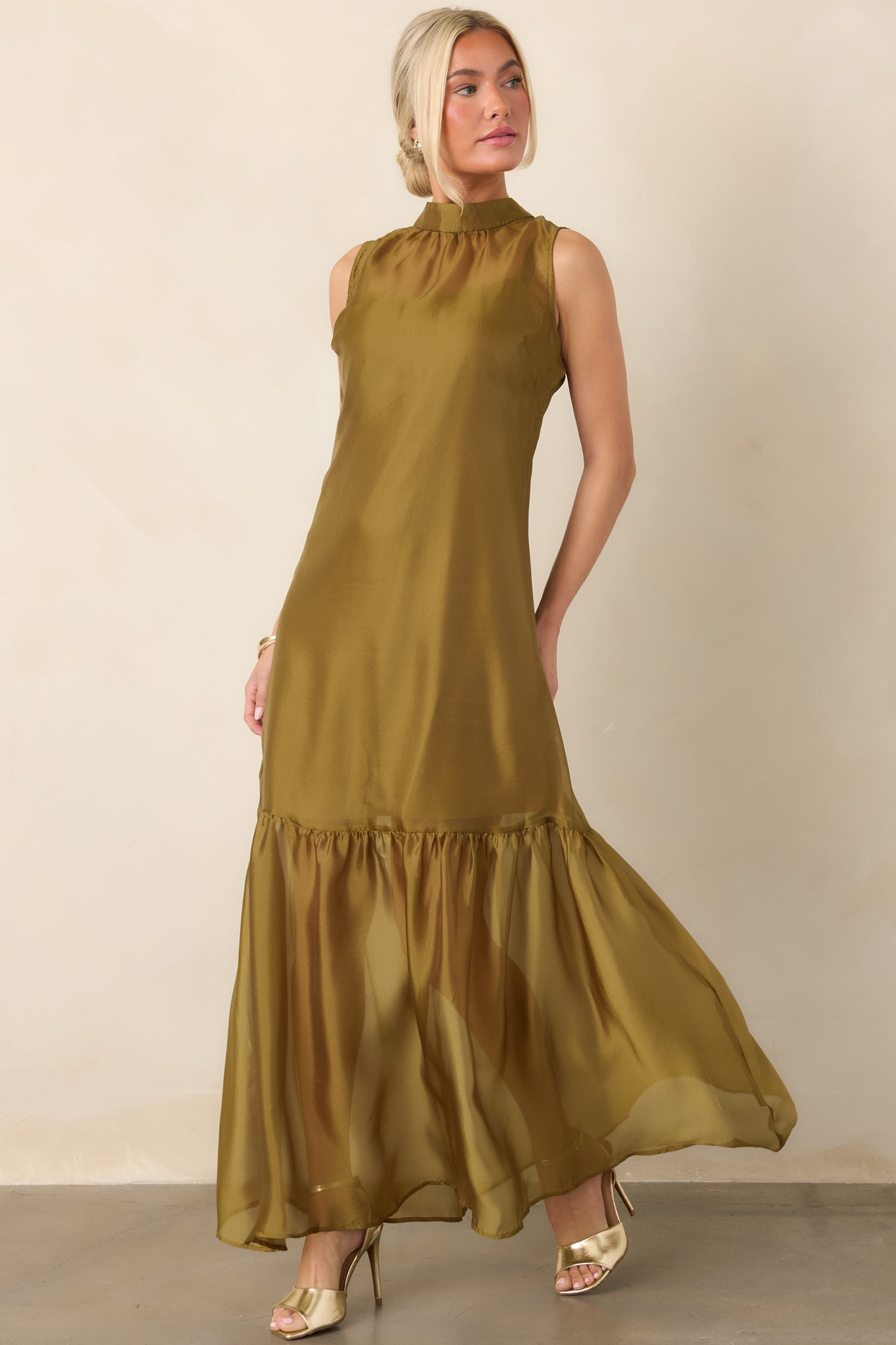 Sheer organza maxi dress with a high neckline, flowing silhouette, softly gathered hem, and mini-length slip lining beneath the skirt.