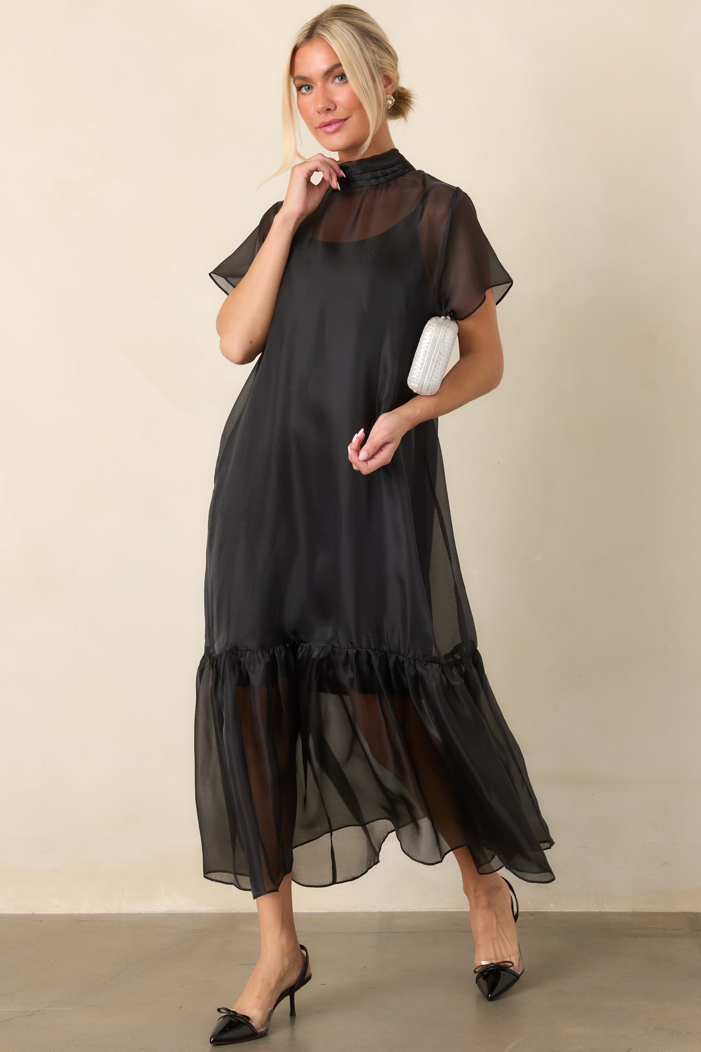 Airy maxi dress with a high pleated neckline, delicate sheer sleeves, and a flowing ruffled hem that adds graceful movement.