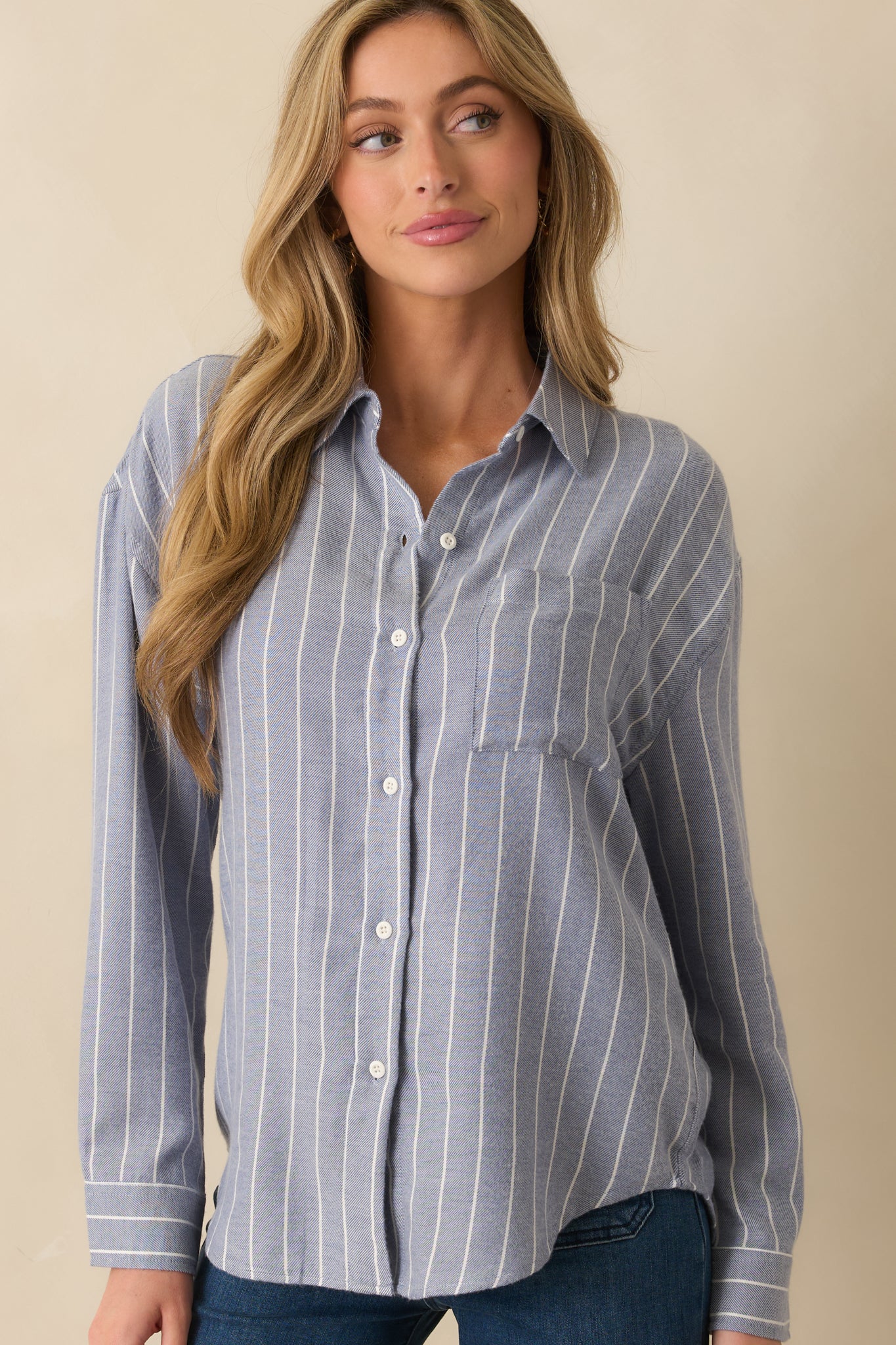 Front crop highlighting buttoned cuffs and soft drape of the shirt’s long sleeves.