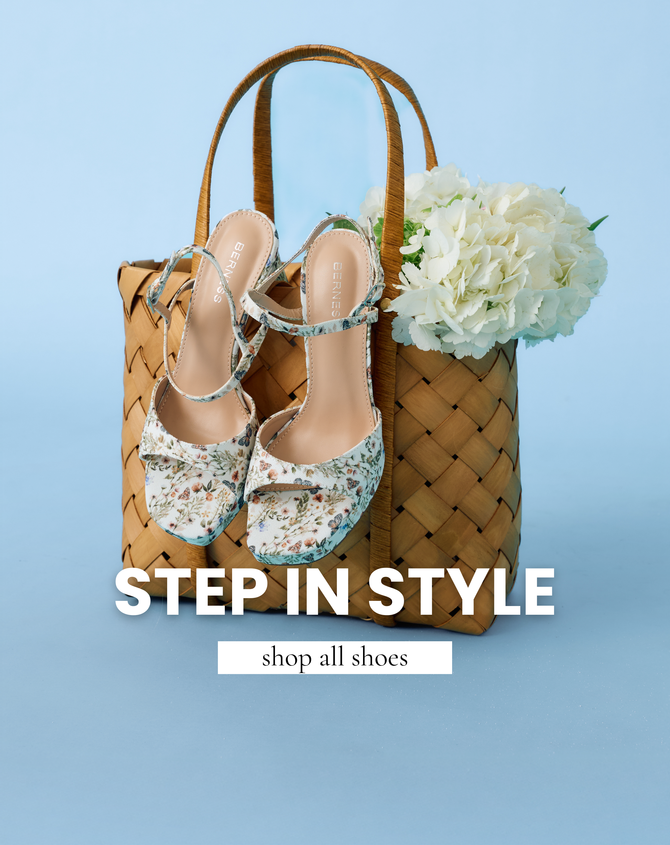 Floral ankle-strap heels displayed on a woven tote bag with white flowers on a blue background, women’s clothing shop linking to shop all shoes.