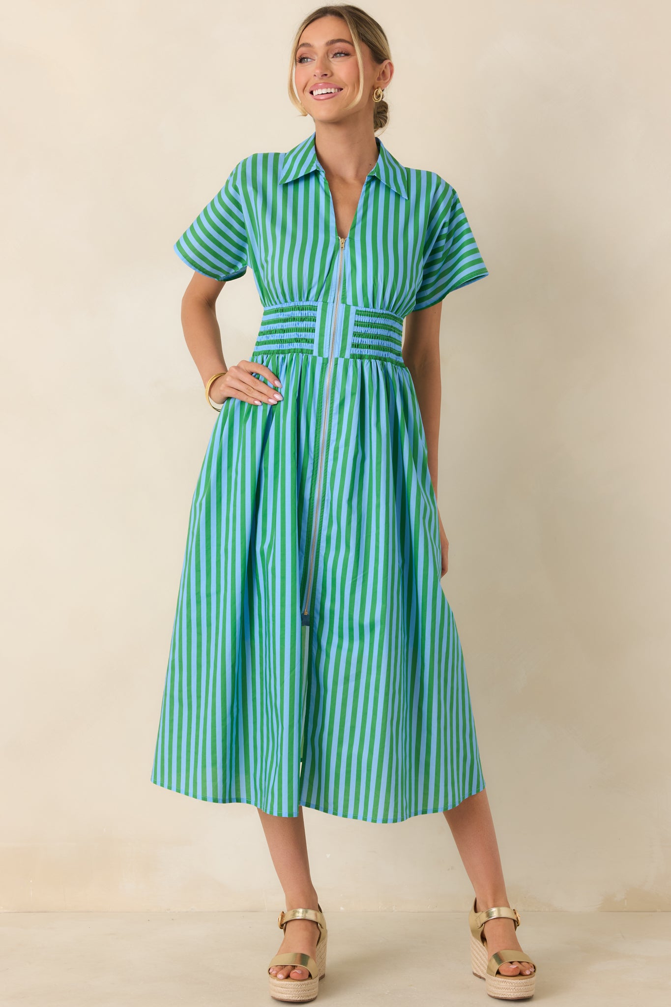 Short-sleeve midi dress in crisp blue and green stripes, flowing skirt, and side pockets for added practicality.
