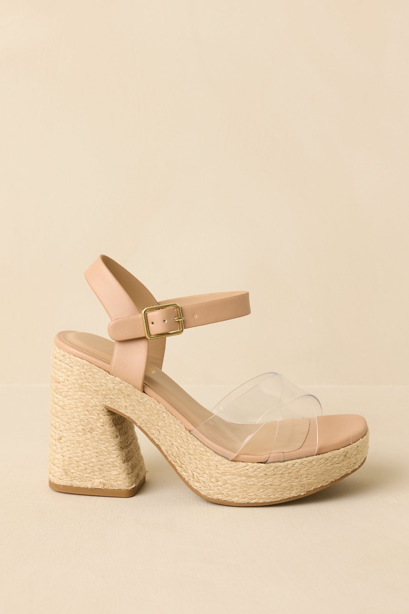 Side angle against a beige background emphasizing the raffia-wrapped block heel and platform base.