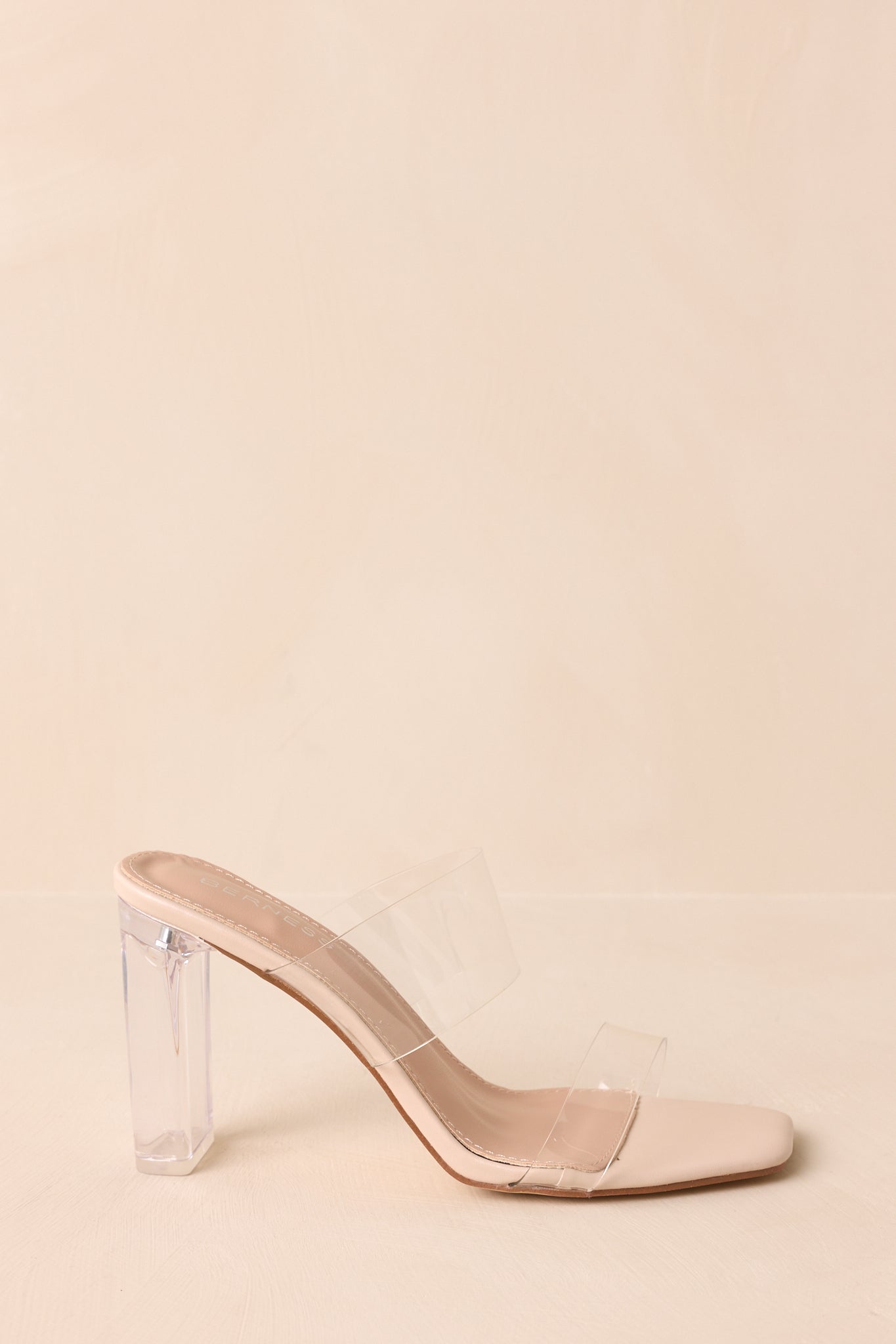 A side cropped angle of the heels highlighting the clear block heel and slip-on design.