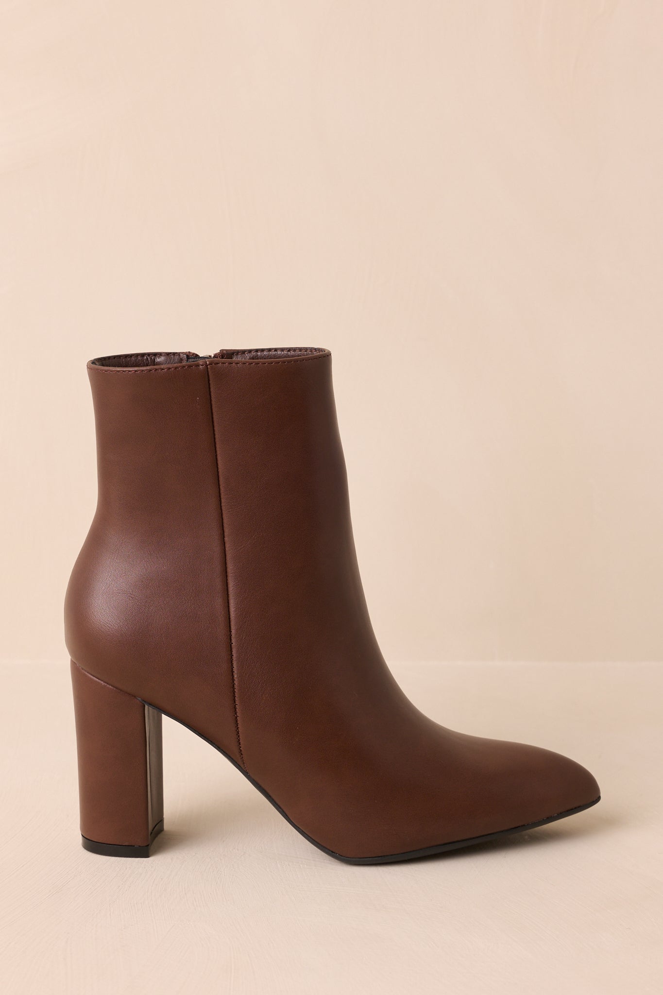A side cropped view of the brown ankle boots highlighting the outer seam detail.
