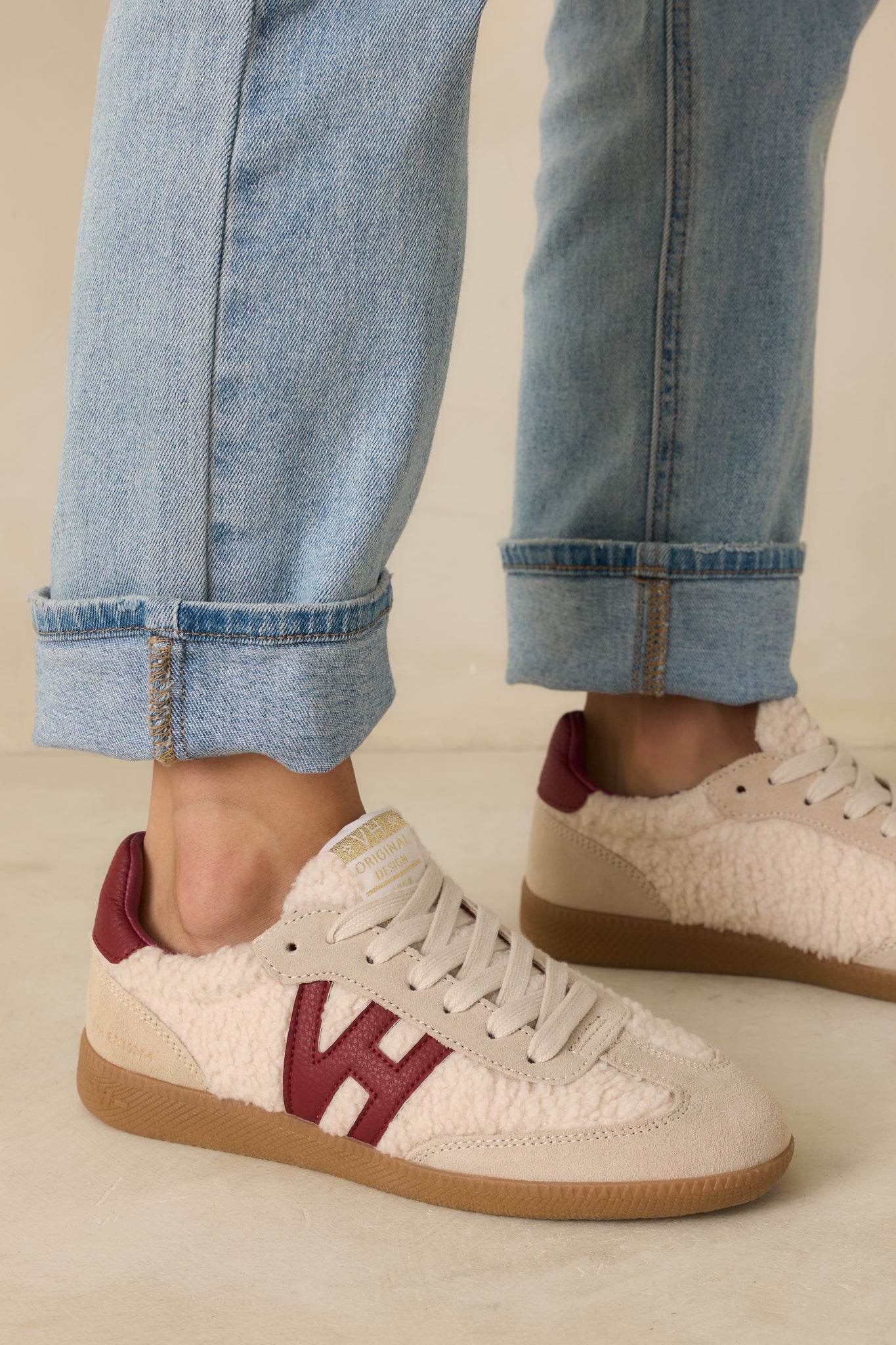 Close-up cropped view of side logo patch, sherpa and suede texture, and stitched paneling.