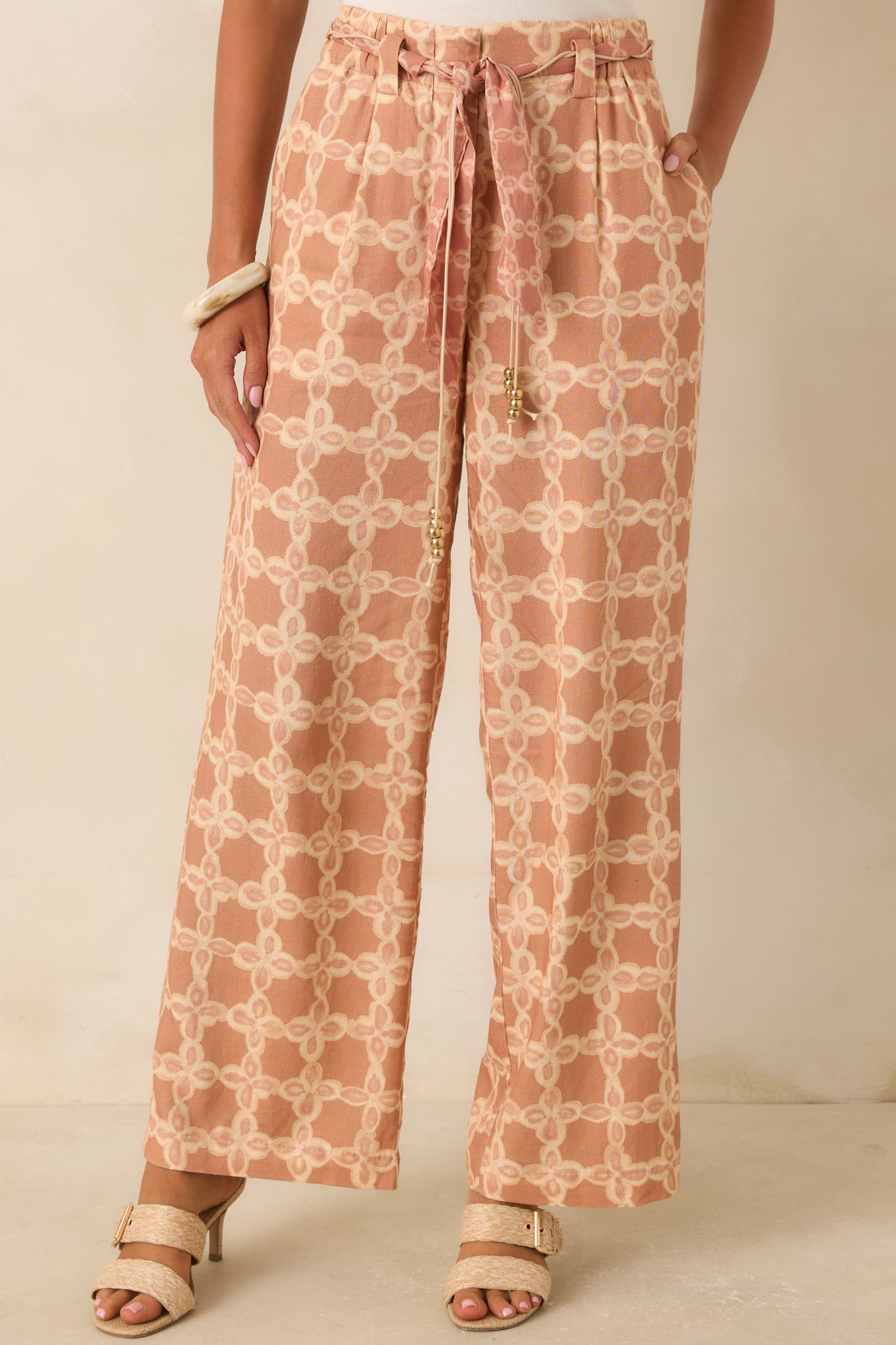 Functional side pockets and a vintage-inspired tan and ivory print highlight the tailored design of these wide leg pants.
