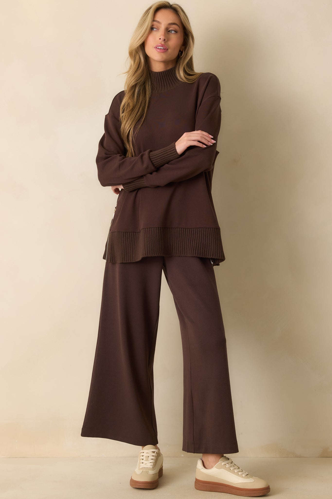 A complete profile of the sweater highlighting its dark brown hue, long sleeves, and overall length.
