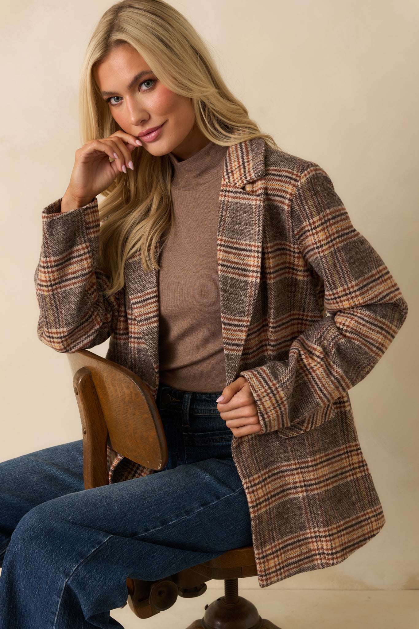 Side angle of the brown plaid overcoat, highlighting the relaxed fit and long sleeves.