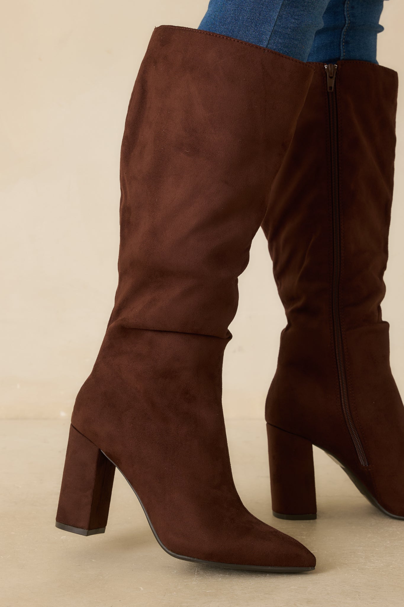 Side view of dark brown knee-high boot featuring tall block heel and softly slouched shaft.