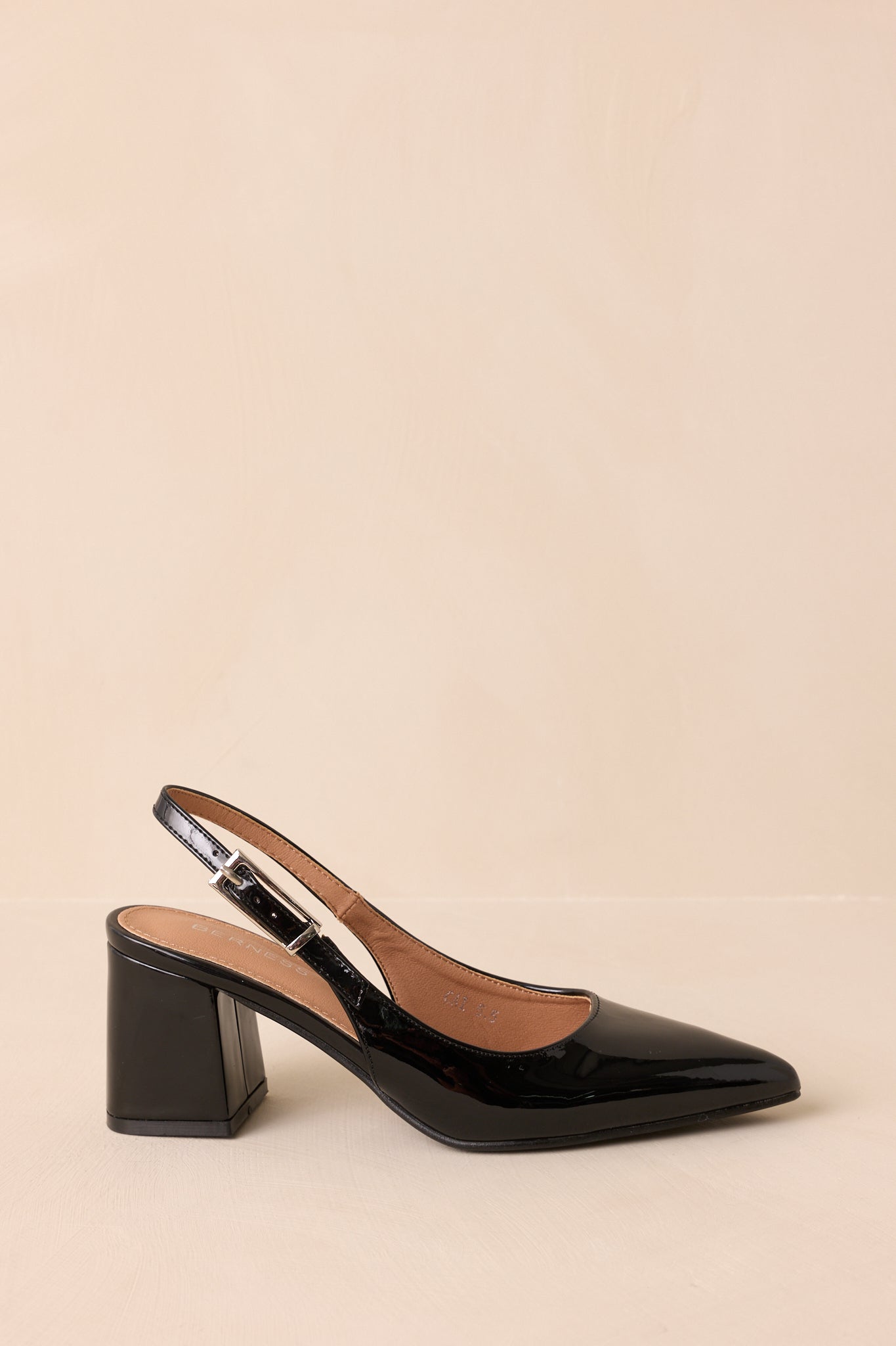 Side view of glossy black heels featuring adjustable slingback strap.