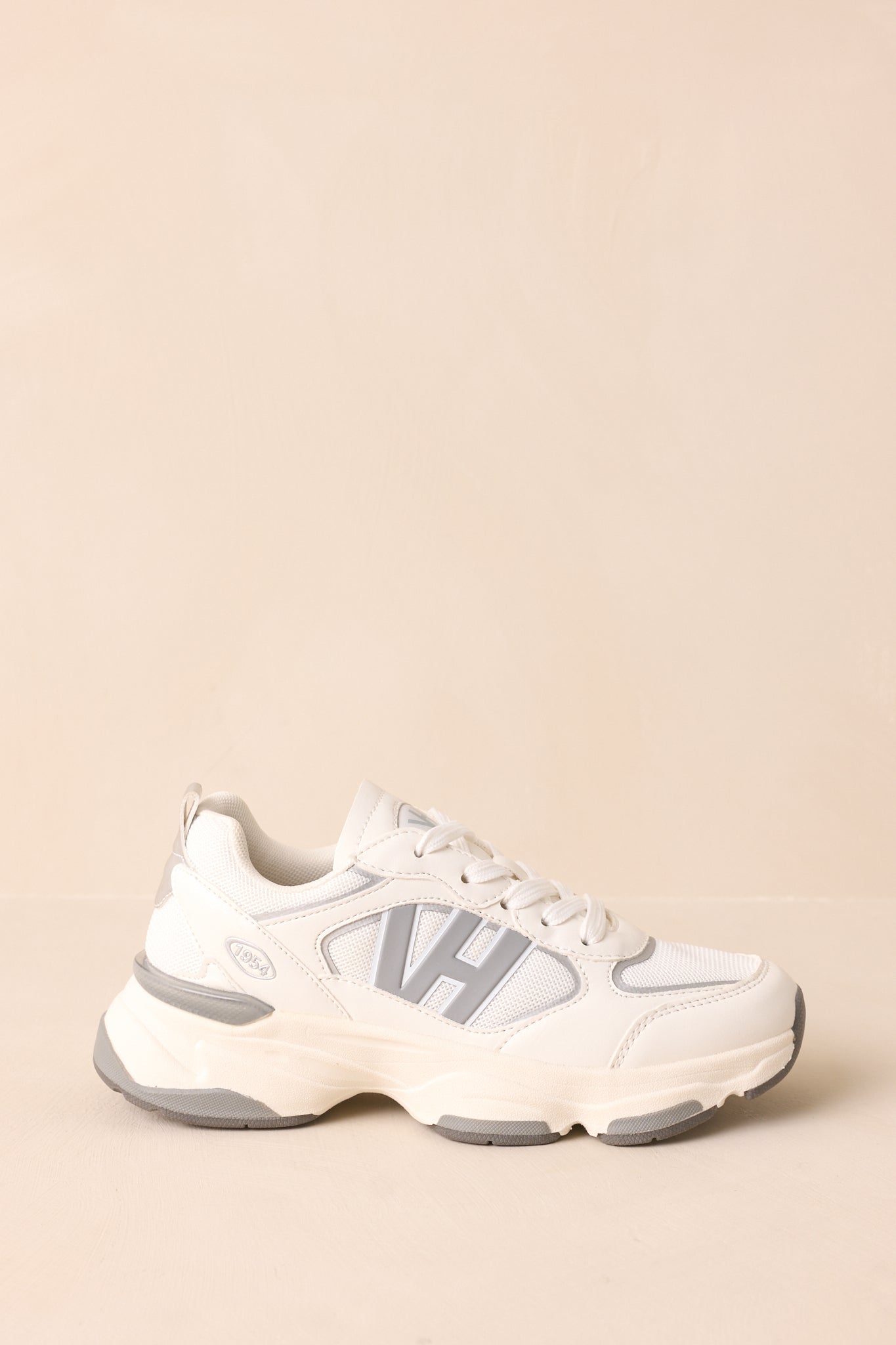 Side view of grey and white sneakers with large raised “VH” logo, rounded sporty shape, and thick cushioned sole with grey accents.