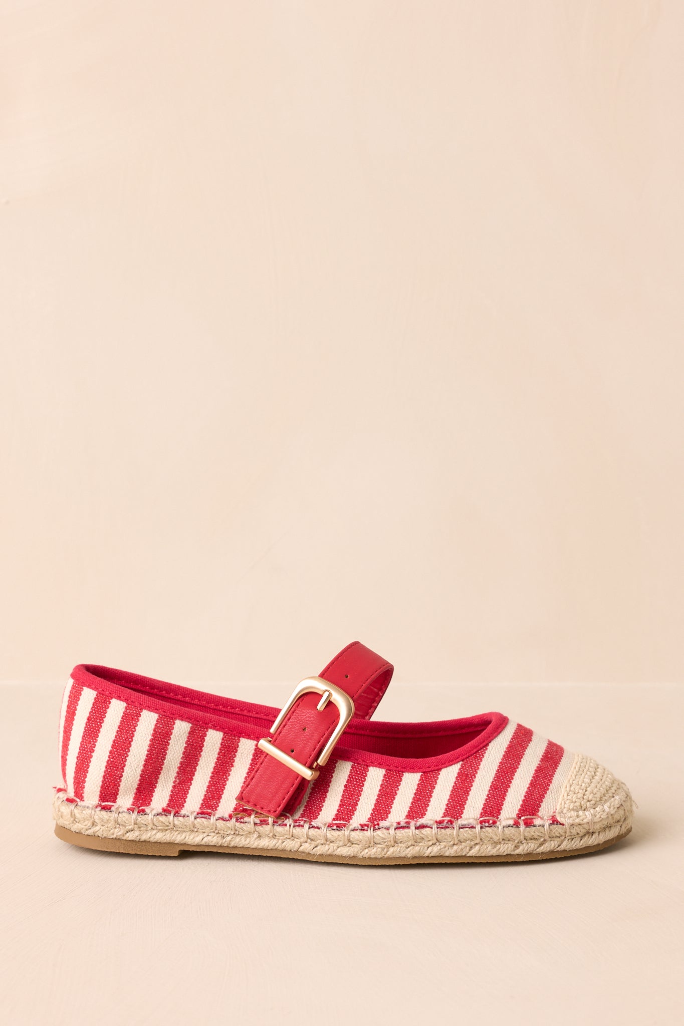 Side cropped view highlighting the braided jute trim along the flat sole and striped canvas upper.