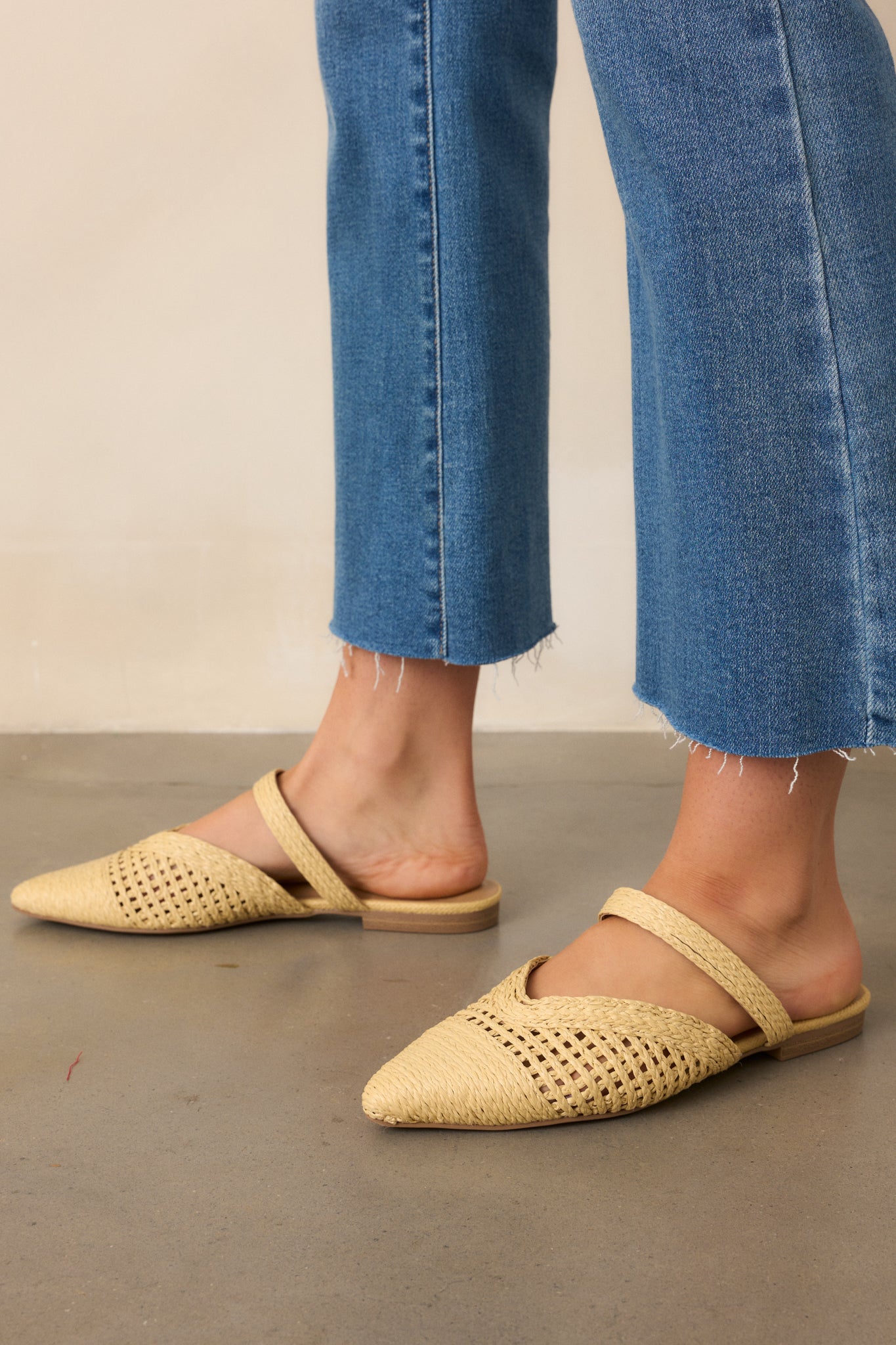 A side view highlighting the closed vamp strap across the top of the foot, adding a stylish detail to the breathable woven raffia flats.