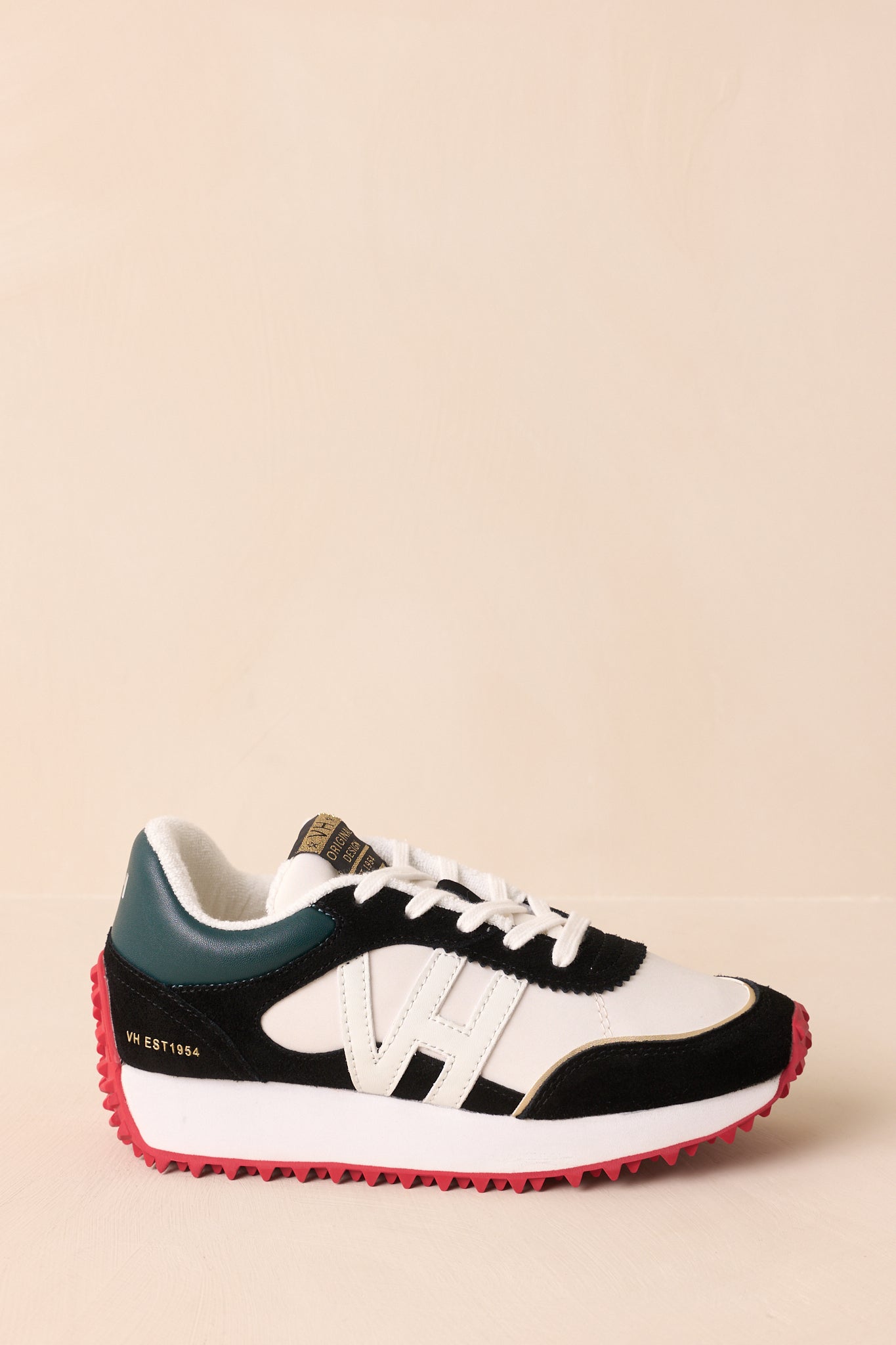 Side view of the sneakers showing the mix of white faux leather and black suede accents.