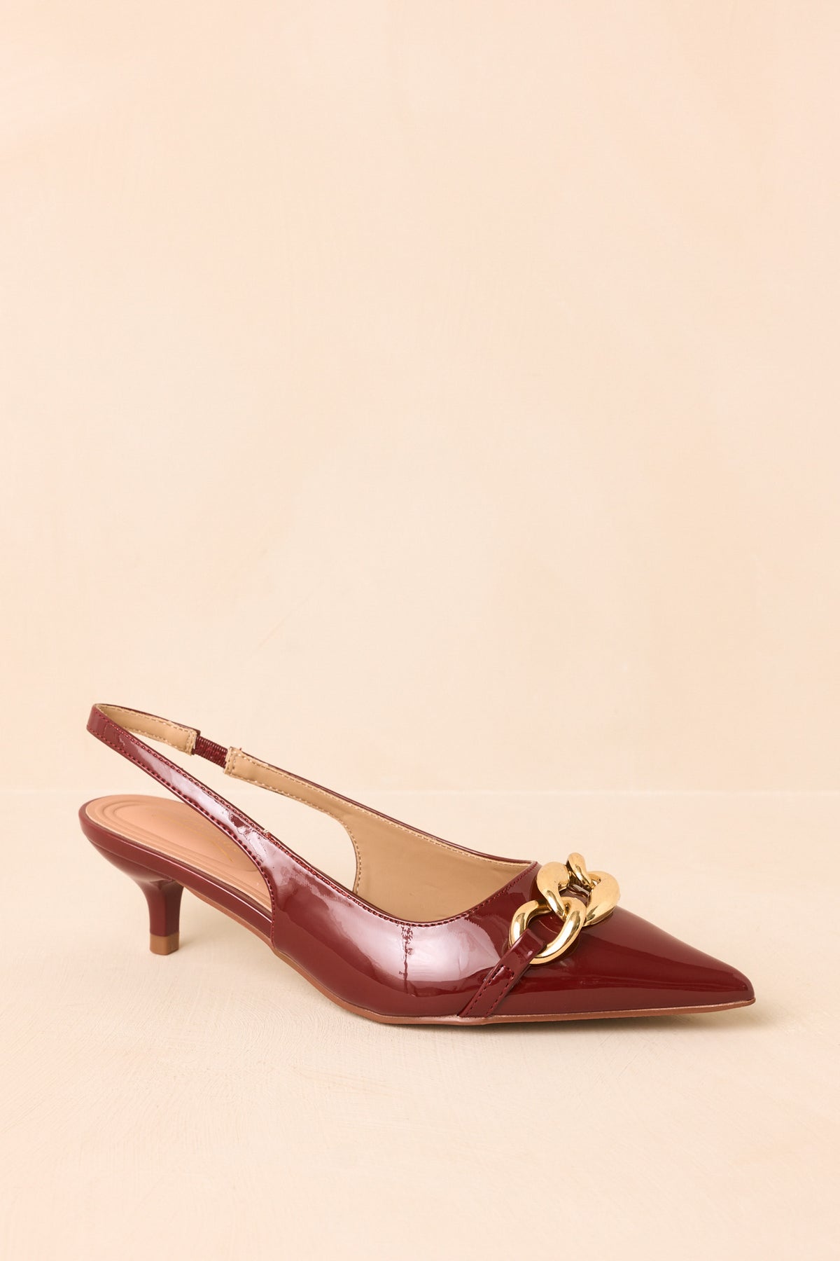 Sienna pointed-toe heels with a bold chain accent and open slingback design.
