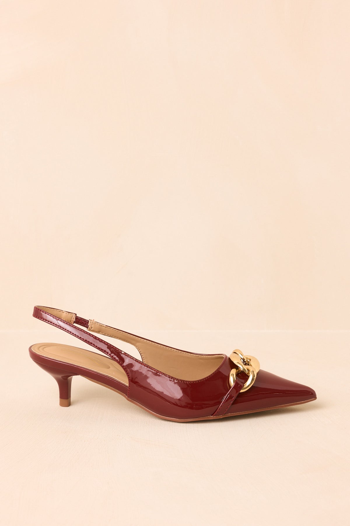 Sienna slingback heels showcasing the pointed toe, kitten heel, and gold-tone chain.
