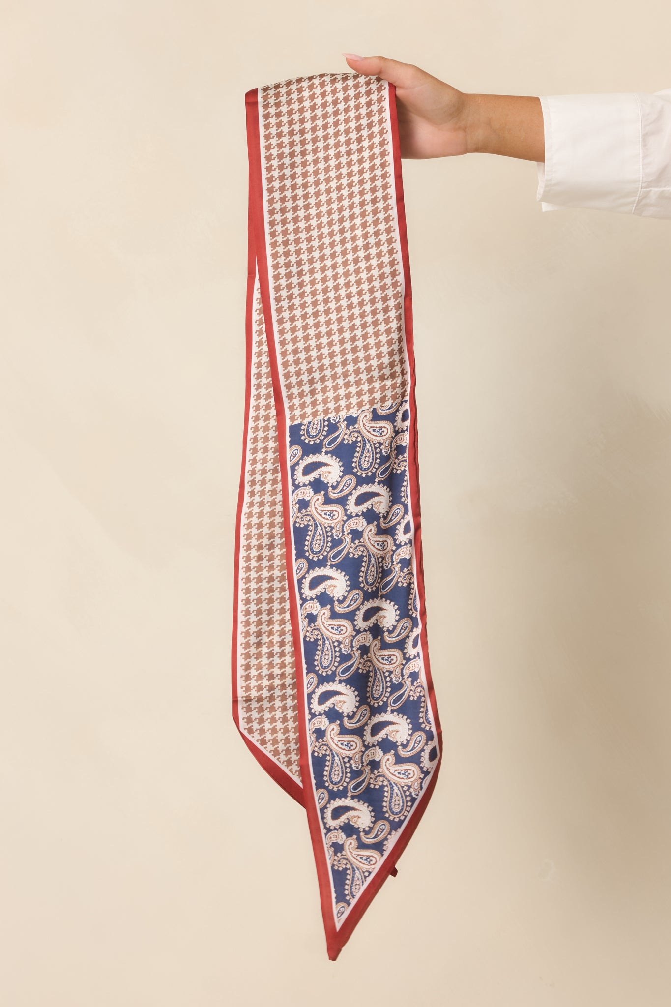 Detailed view of the silky scarf showcasing the blue paisley pattern, camel houndstooth, and colorful border design.