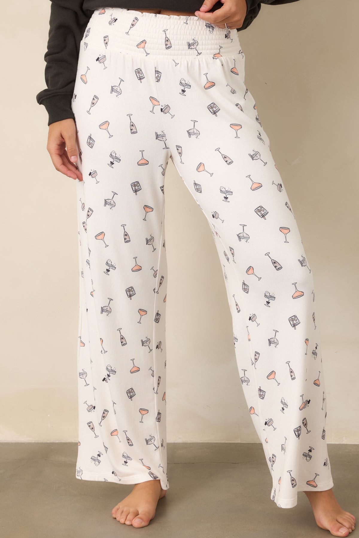 Silky stretch jersey pants displaying playful cocktail motifs and tiny spooky details throughout the ivory fabric.