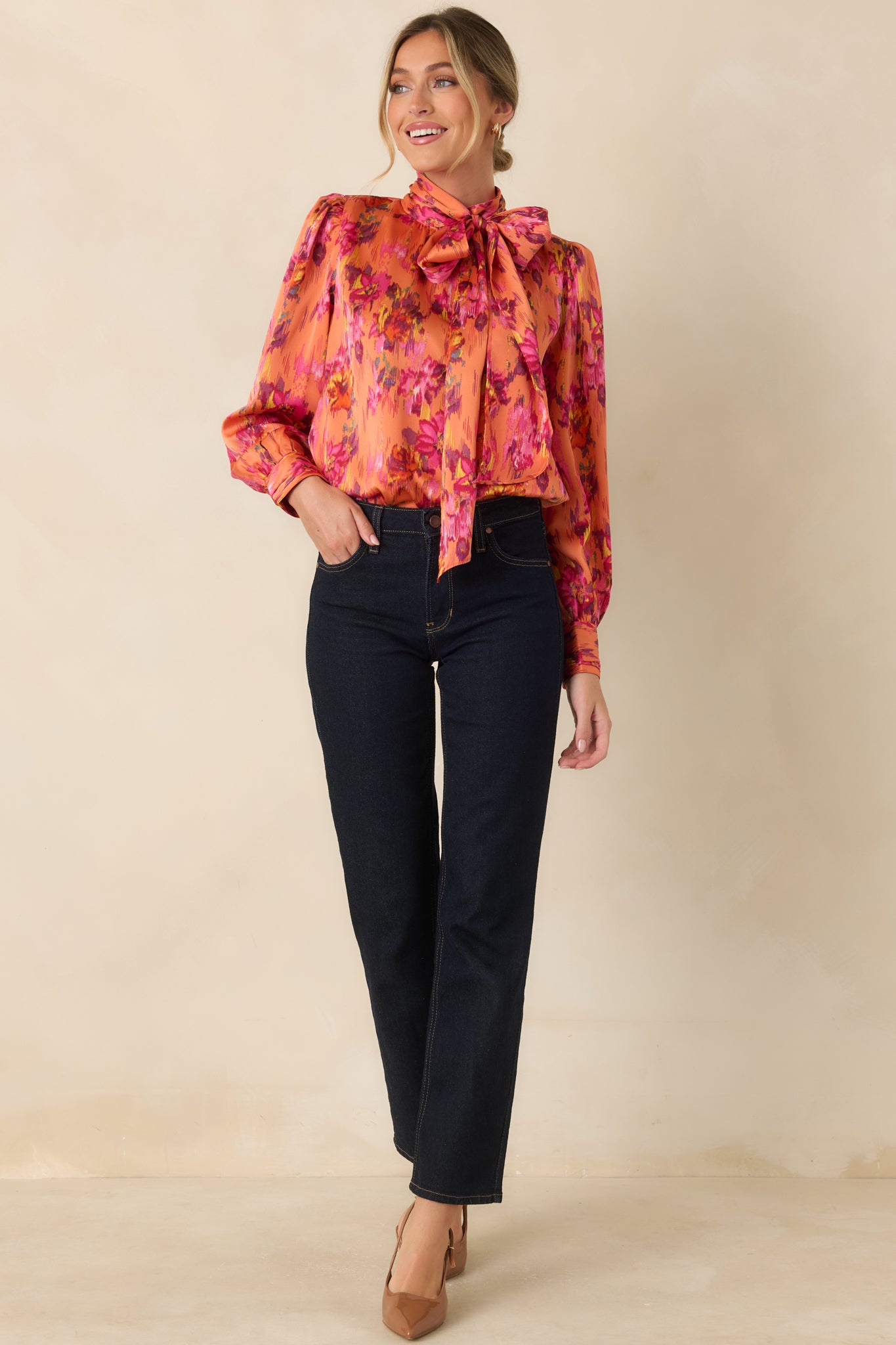 Smooth satin blouse showcasing a statement tie neckline, gathered shoulder details, voluminous balloon sleeves, and buttoned cuffs.