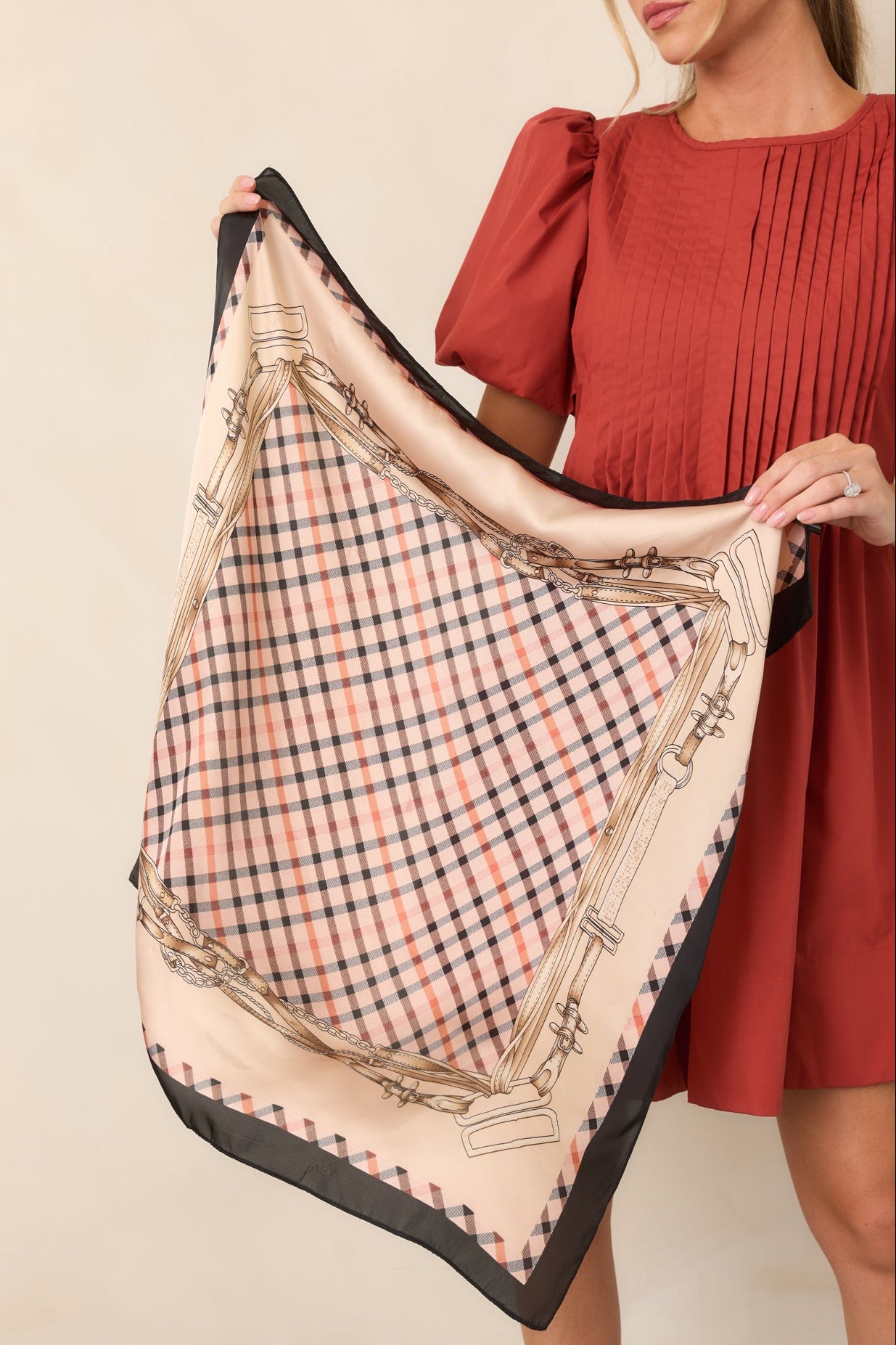 Silky satin hair scarf featuring a neutral plaid center framed by decorative horse bridle, chain, and leather strap motifs.