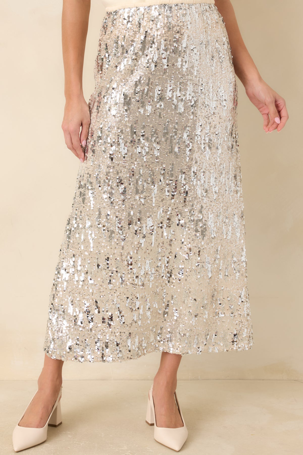 Silver sequins in assorted sizes create a shimmering textured finish across the ivory skirt.