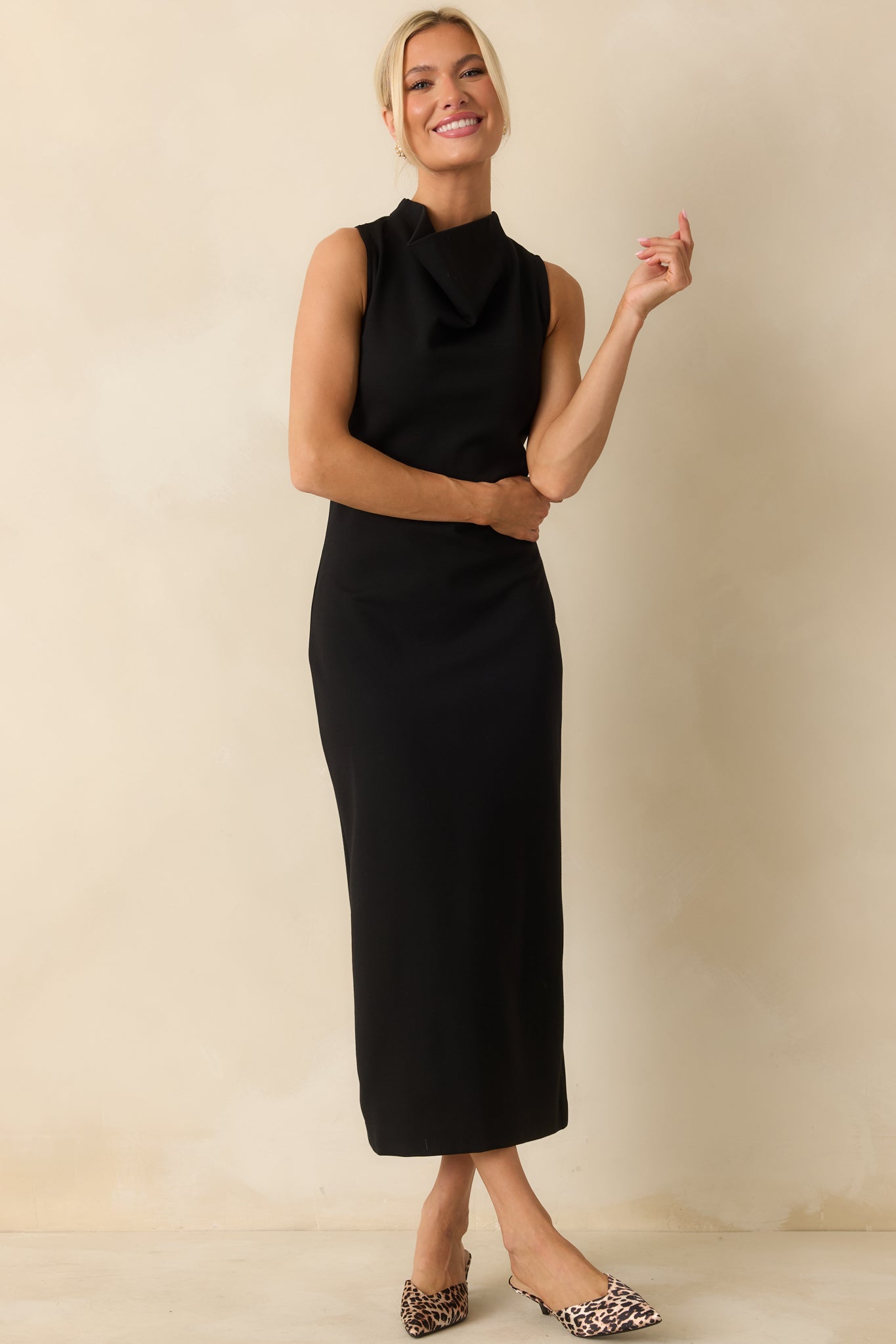 Sleek black sleeveless midi dress with a high neckline and bodycon fit, crafted from stretchy ponte fabric for a smooth, figure-hugging silhouette.