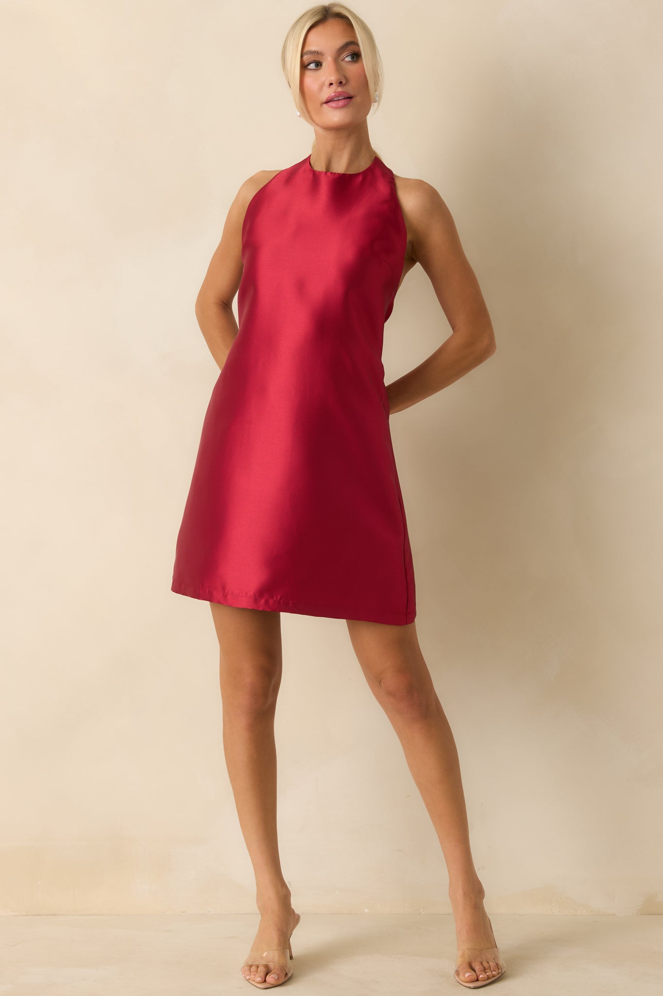 Sleek red mini dress featuring a halter top and flowing A-line skirt.