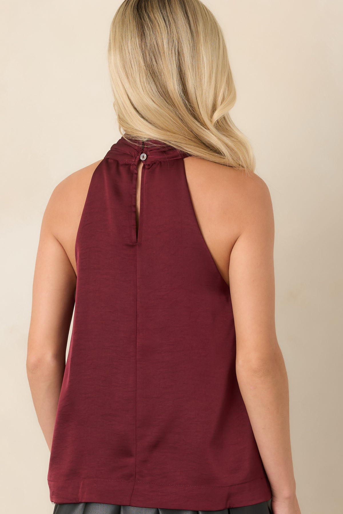 Rear of the sleeveless blouse showcasing its softly draped silhouette and halter neckline.