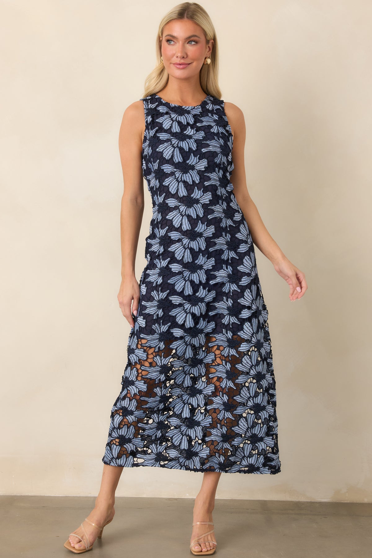 Sleeveless floral dress showcasing the contrast of oversized blue blooms and a softly flared lace-accented skirt.