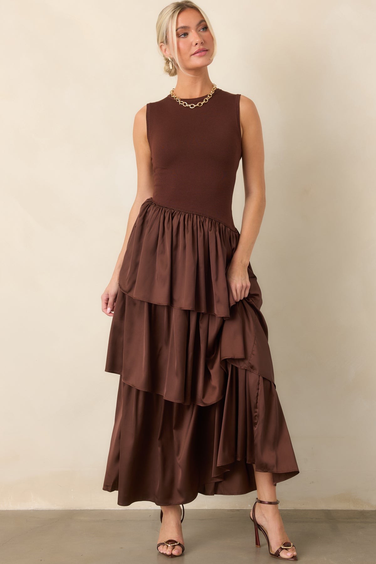 Sleeveless chocolate brown dress highlights the combination of a fitted knit top and movement-ready layered skirt.
