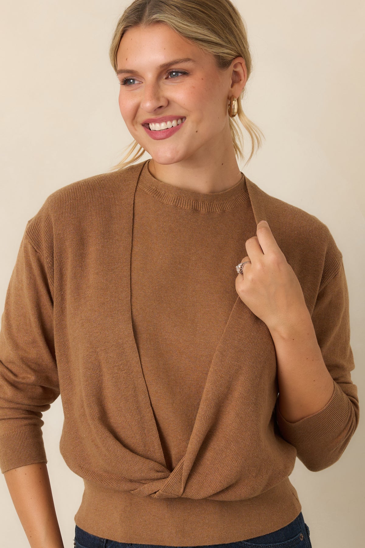 Sleeveless crewneck knit base paired with a coordinating long-sleeve overlay twisted across the front.
