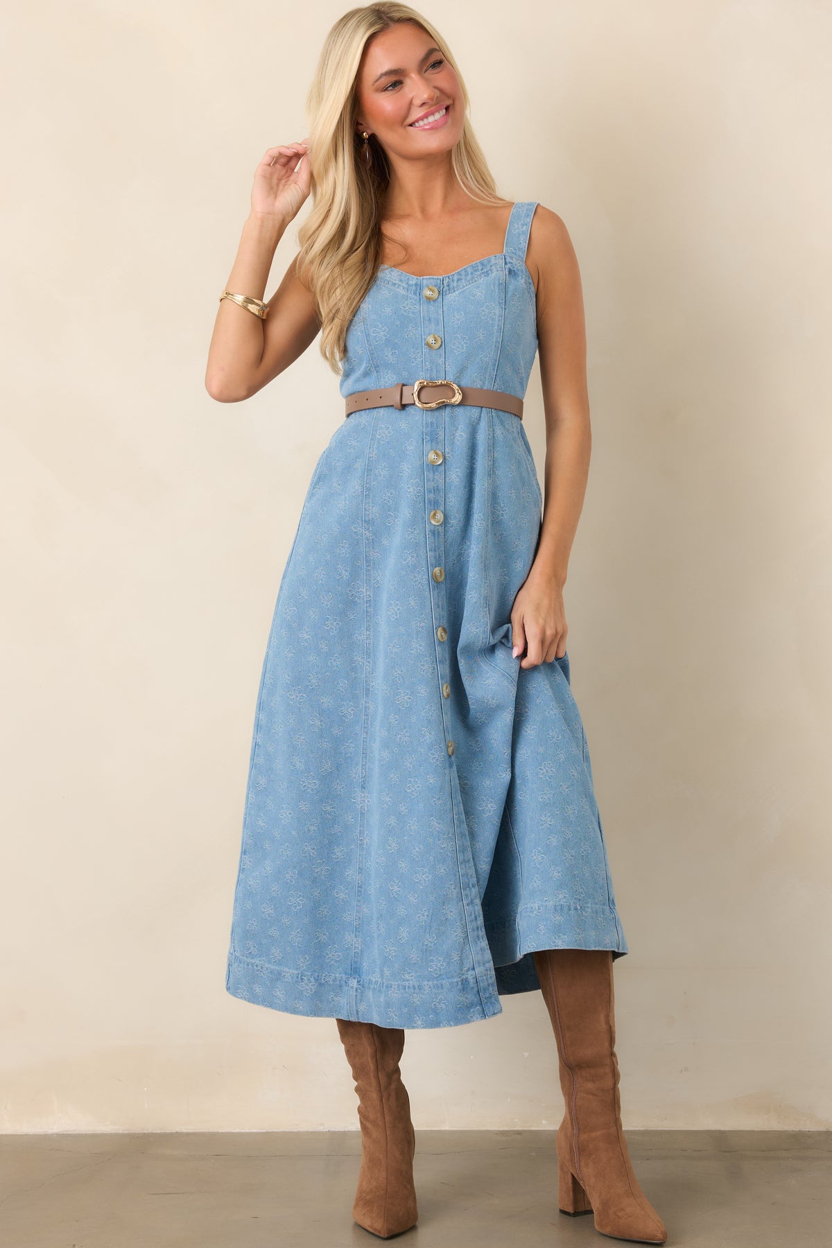 Sleeveless denim midi dress highlighting the adjustable straps, structured bodice, and feminine A-line silhouette.