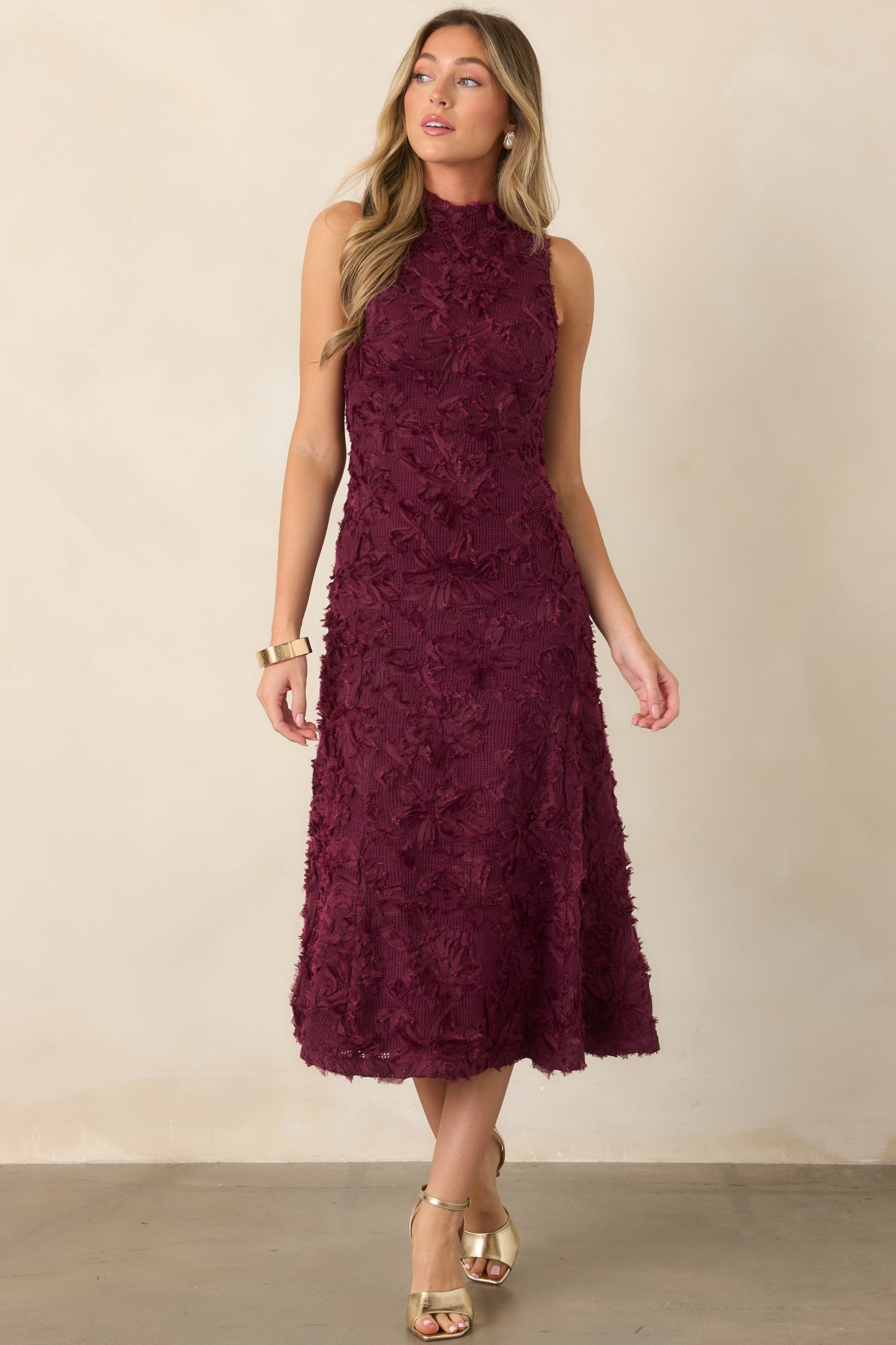 Elegant sleeveless dress with dimensional floral embellishments, a close-fitting bodice, and a fluid flared midi skirt.