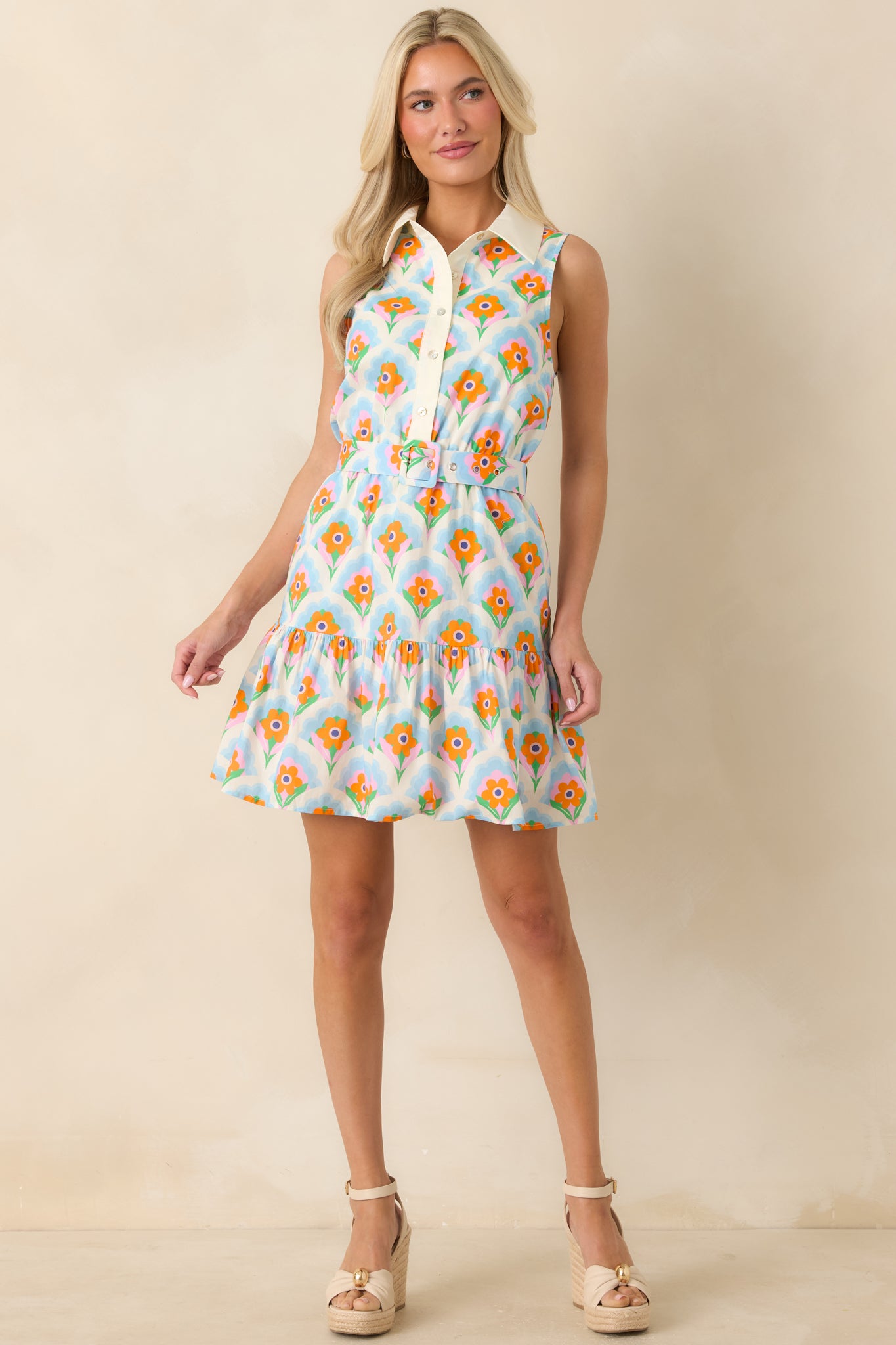Sleeveless orange and light blue mini dress showcasing a functional button front and a softly flared ruffle hem.