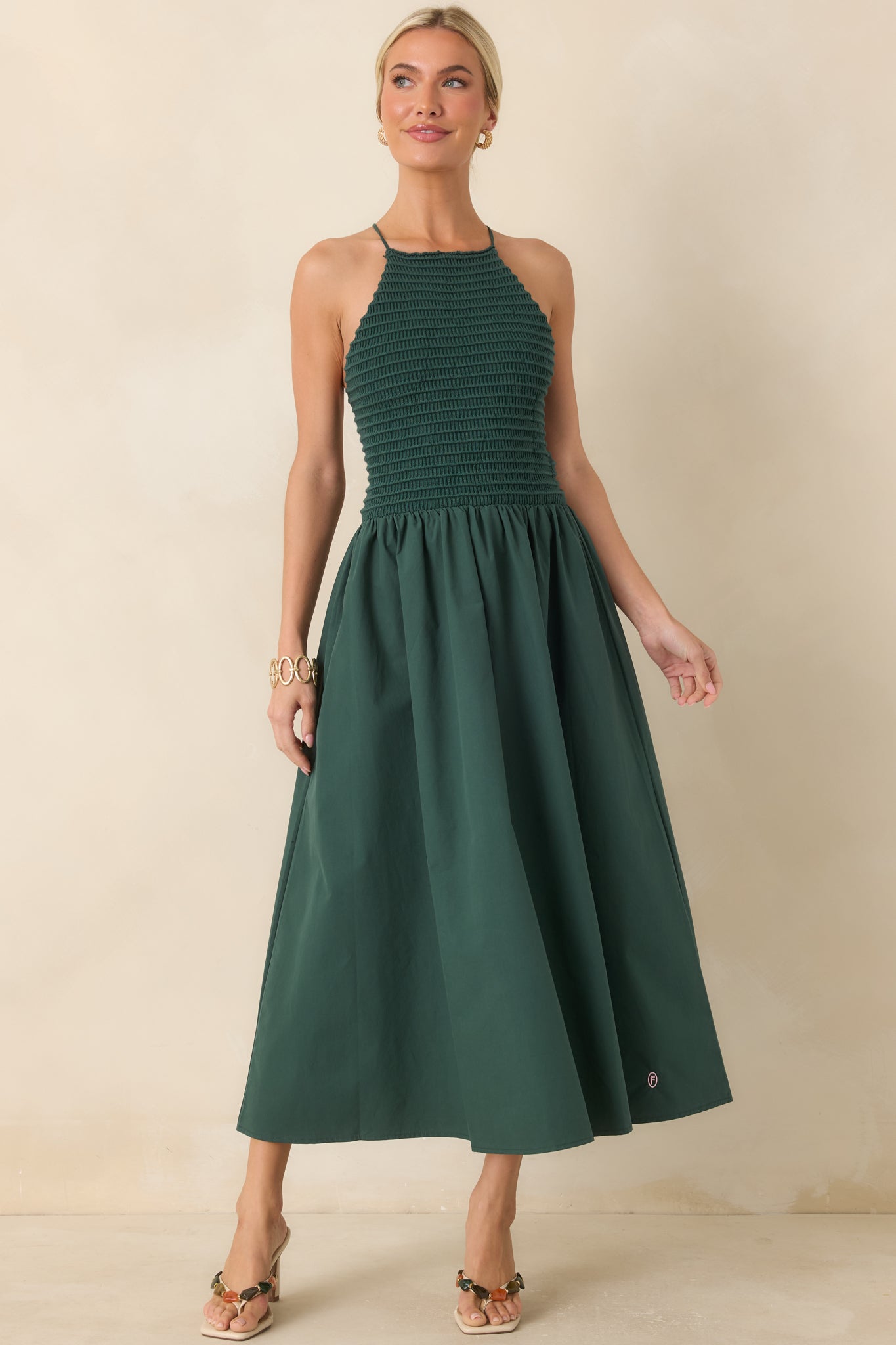Sleeveless green midi dress with a flattering fitted bodice, elegant halter neckline, and a lightweight cotton skirt with an easy flowing shape.