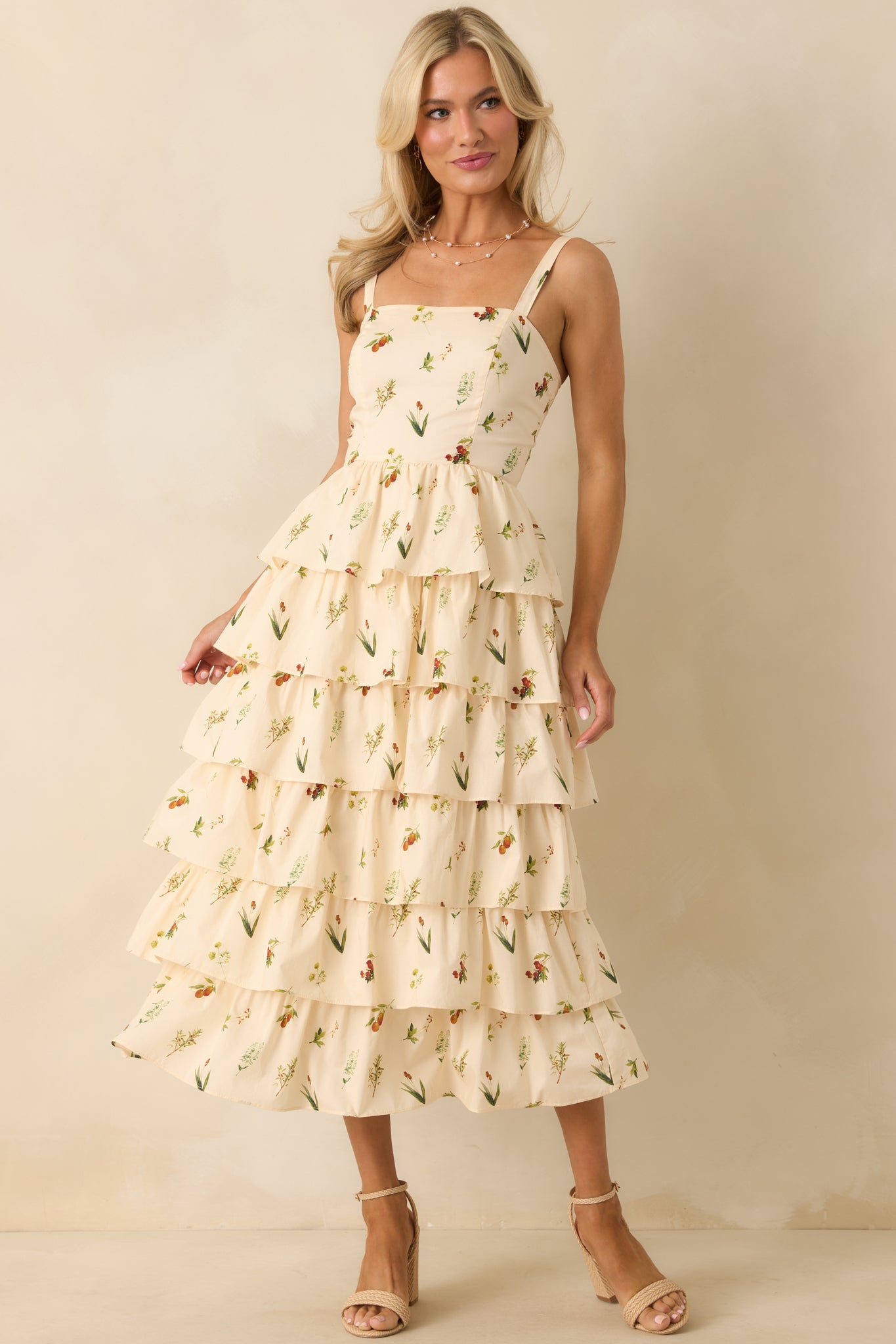 Sleeveless ivory midi dress with tiered skirt and subtle elastic details at the shoulders.